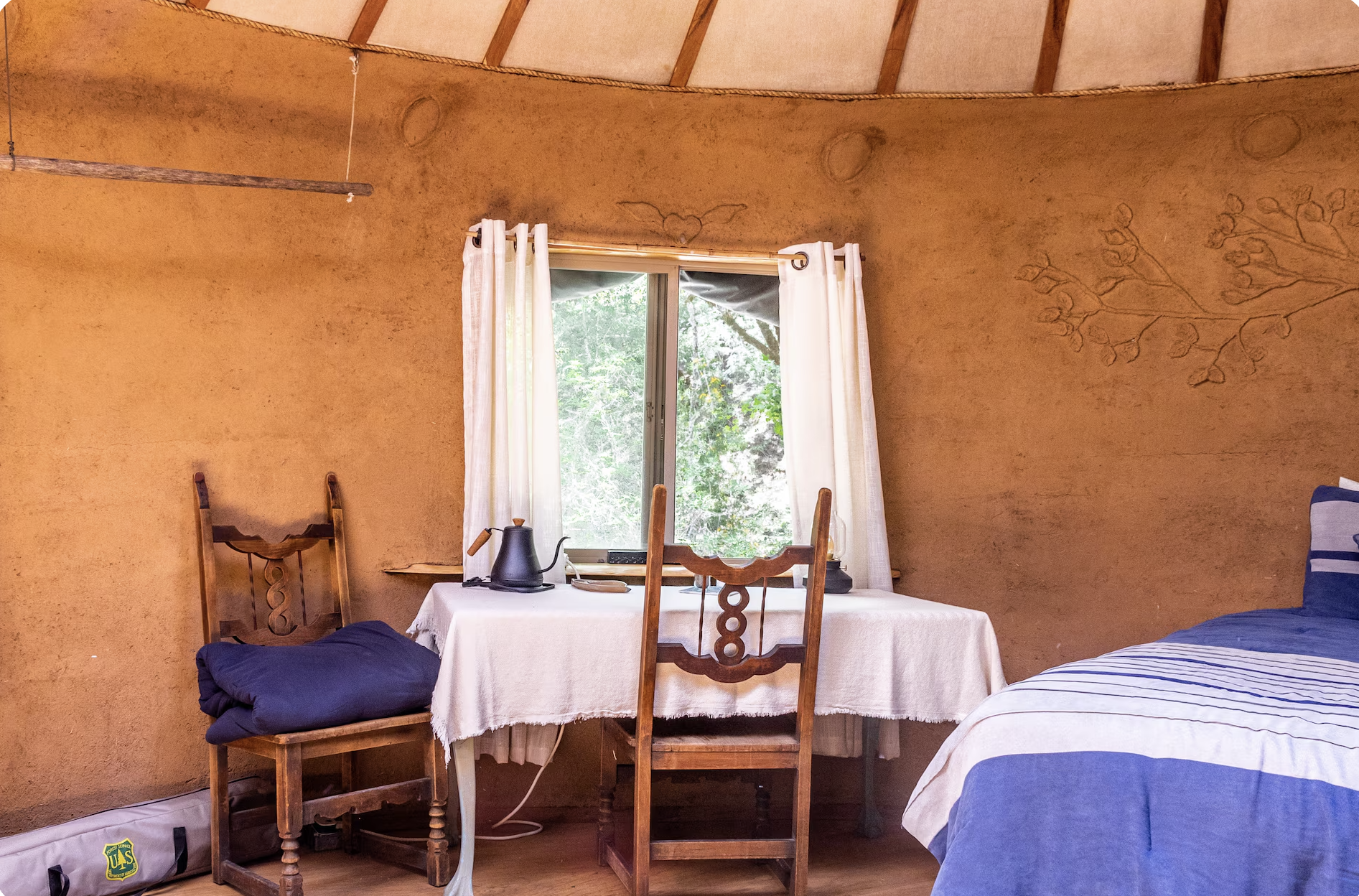 The Earthen Yurt ~ Drift into dreams beneath the captivating Tree of Life headboard, surrounded by lunar cycles adorning the interior walls.