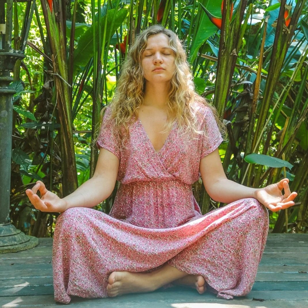 Woman meditating in nature during an emotional alchemy workshop focused on releasing limiting beliefs, emotional blocks, and patterns at a women’s healing retreat in Northern California.