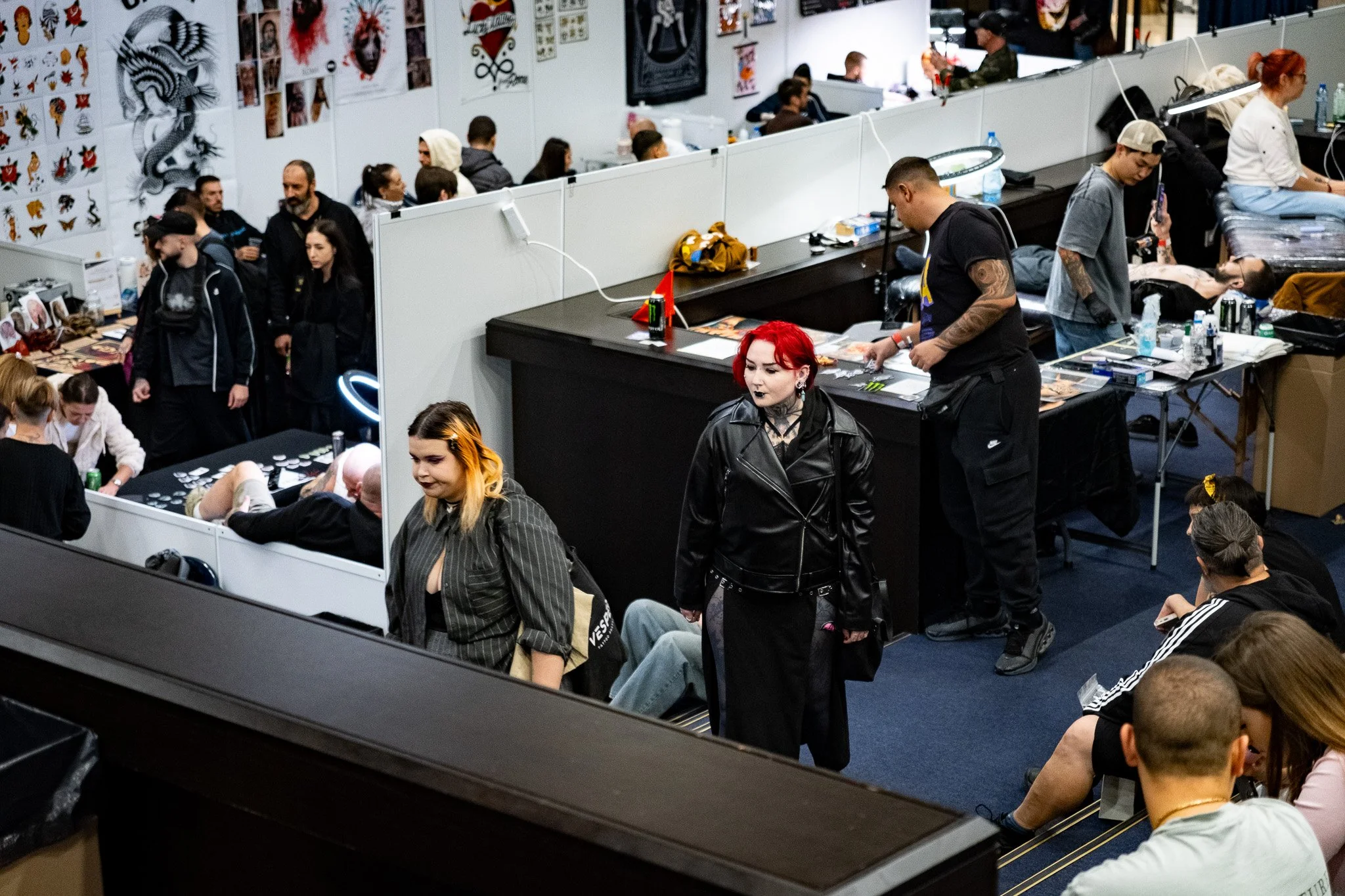 People waiting and getting tattoos at a tattoo convention or studio.