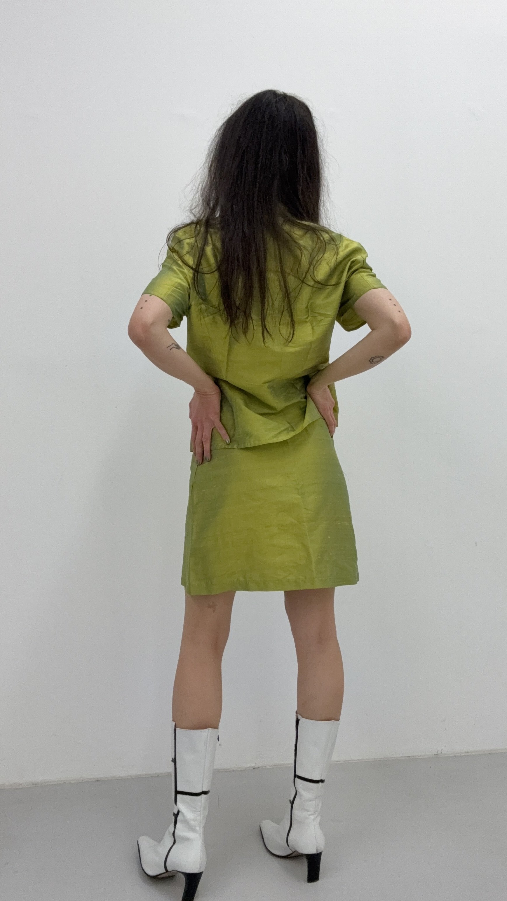 A shot from the back of a Stefanel vibrant green silk set, highlighting the fluid fit and sophisticated design.