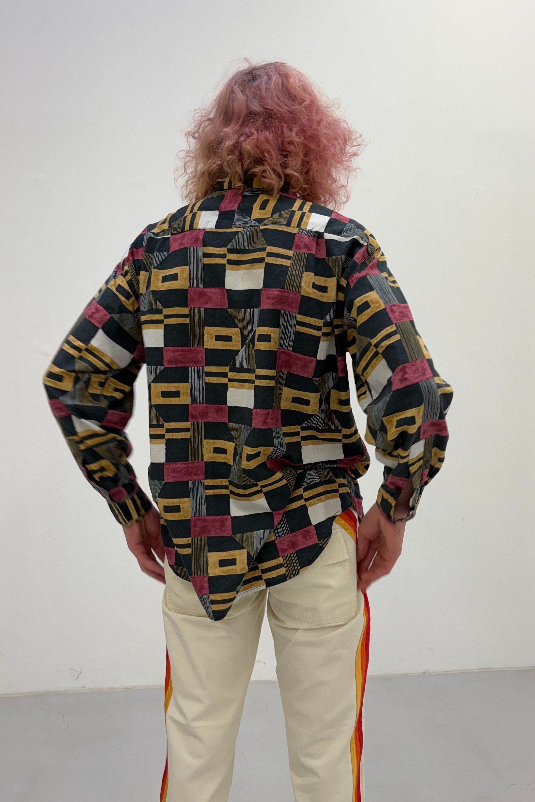 A back view of a vintage Italian button-up shirt featuring detailed, colorful patterns and a classic fit.