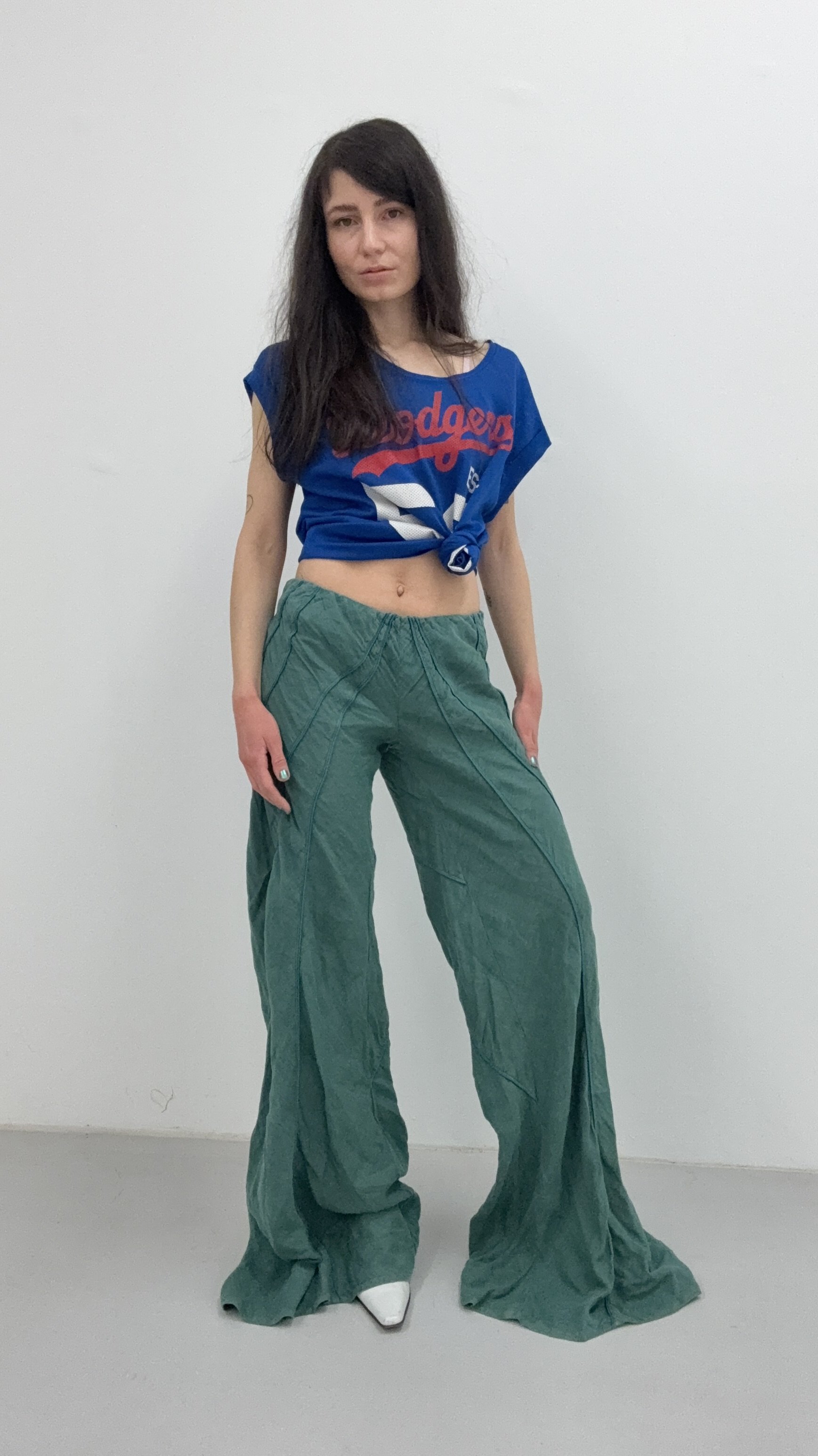 A photo of a pair of vintage Italian flowy green oversized trousers, highlighting their relaxed fit and soft fabric.