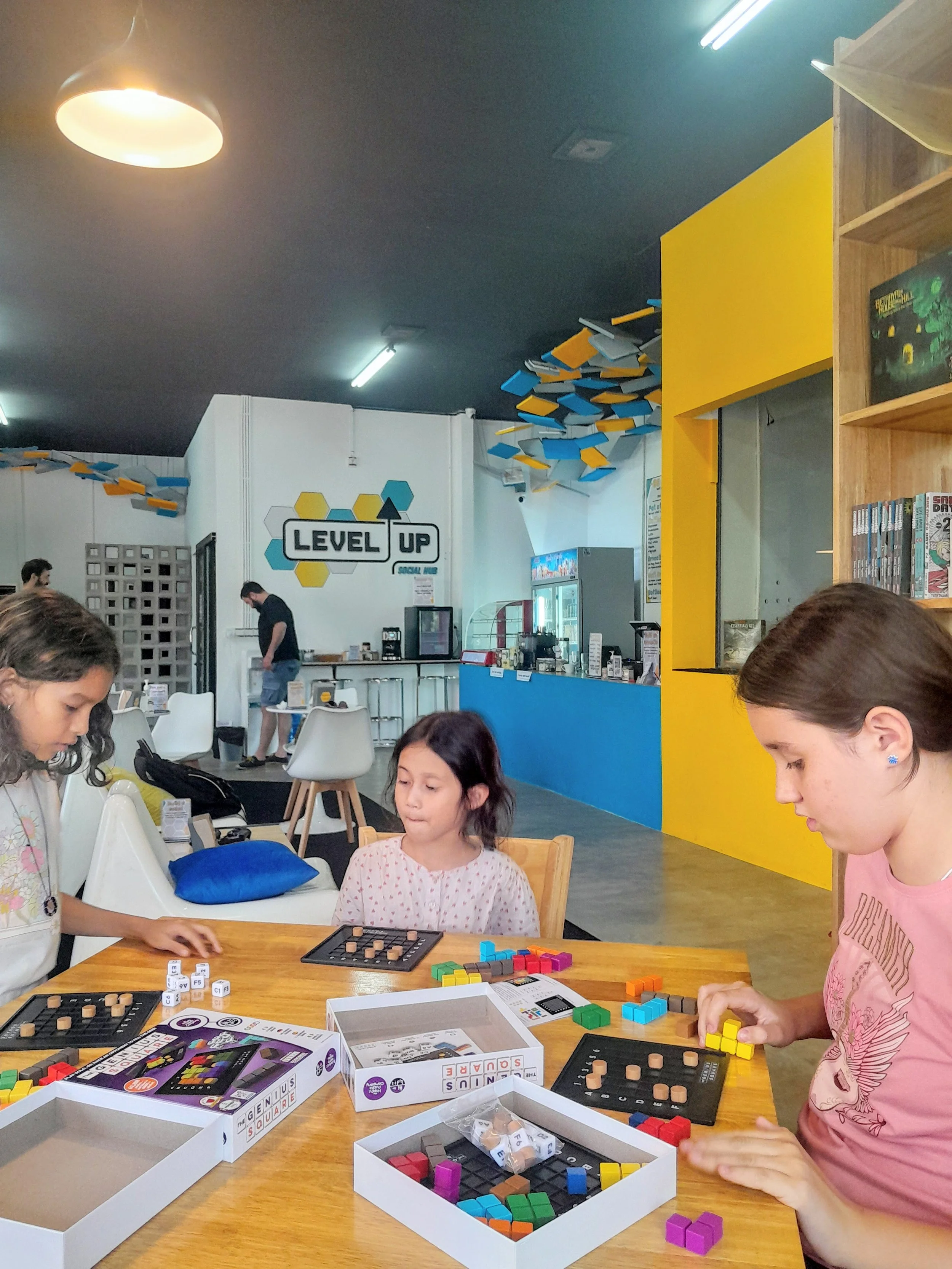 Families playing board games in the air-conditioned Level Up social hub near Wat Damnak, Siem Reap.