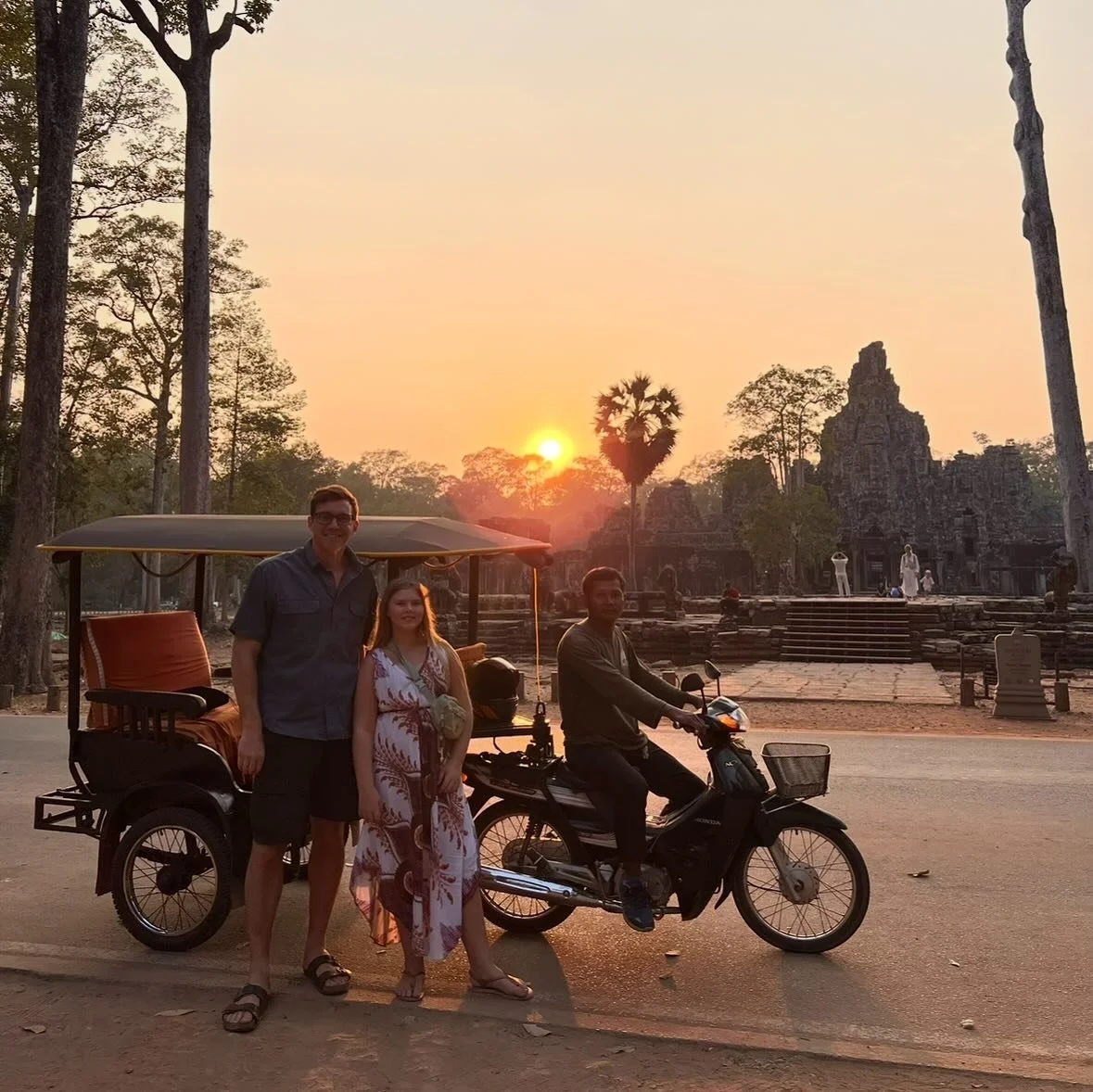 Family posing with their Babel Tuk-Tuk driver at the South Gate of Angkor Thom during a peaceful temple sunset tour, Siem Reap.