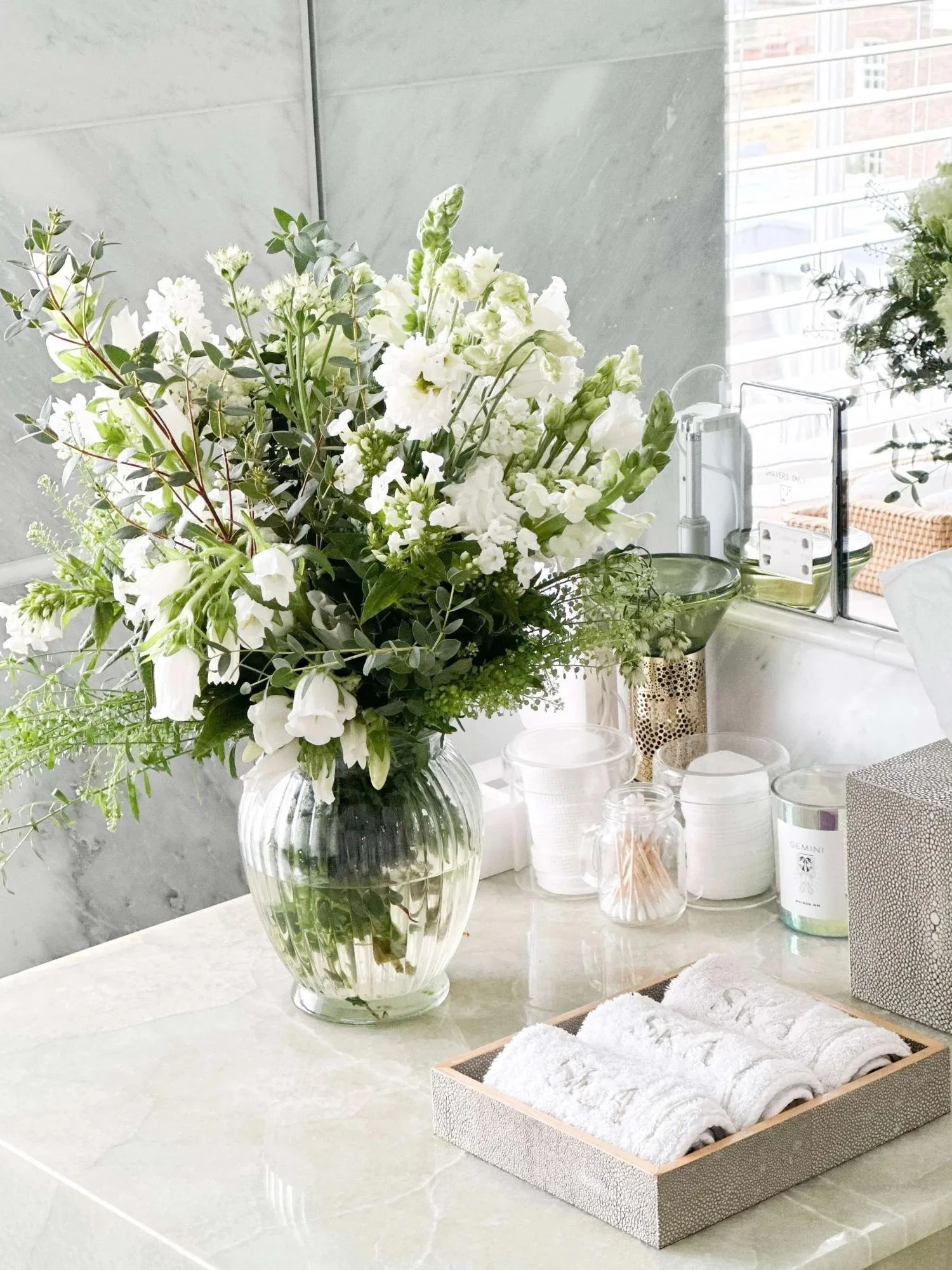 Bathroom accessories are decanted and readily accessible in this light and bright organised bathroom