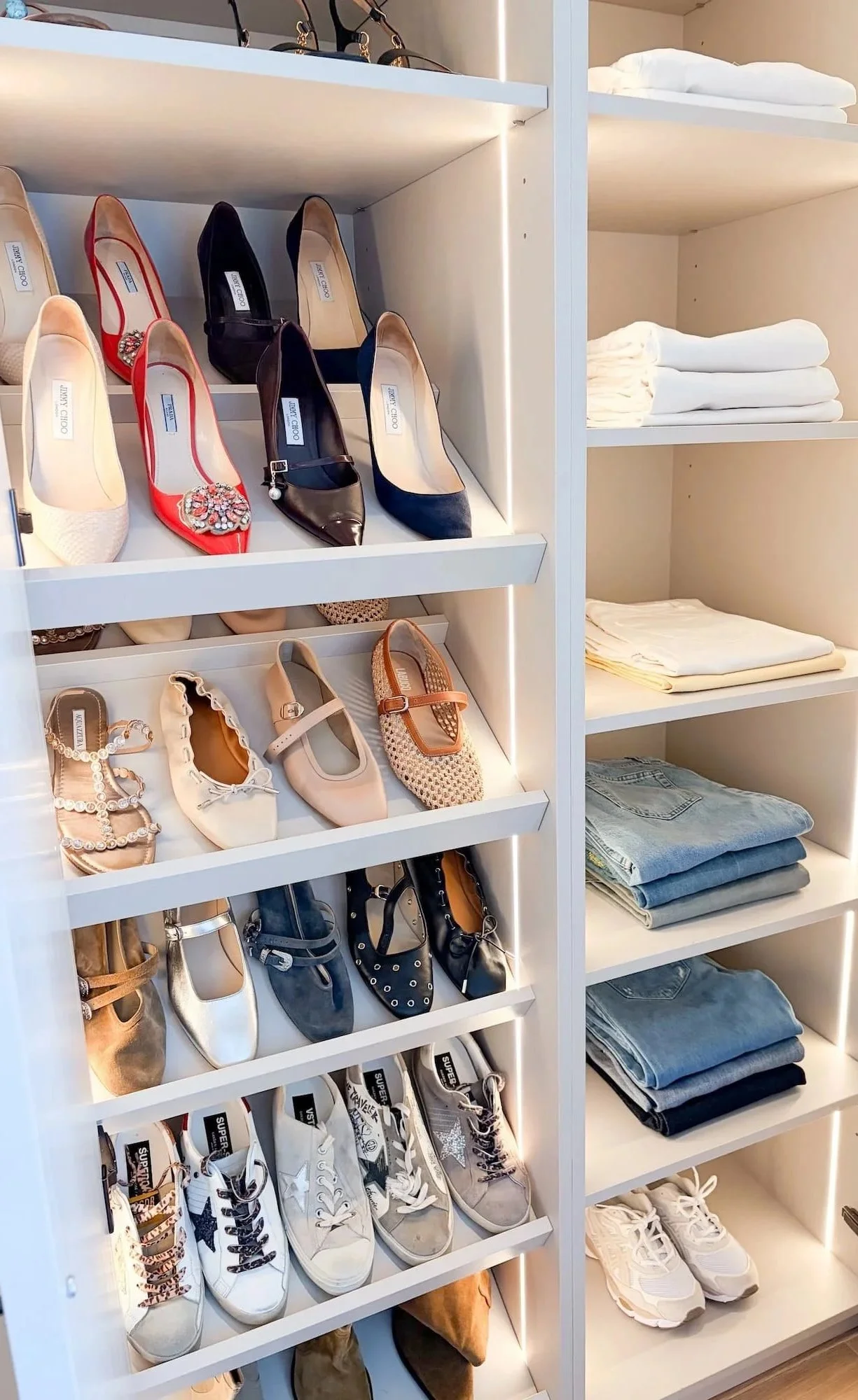 Shelves with various women's shoes including high heels, sneakers, and flats, alongside neatly folded clothing like jeans and t-shirts.