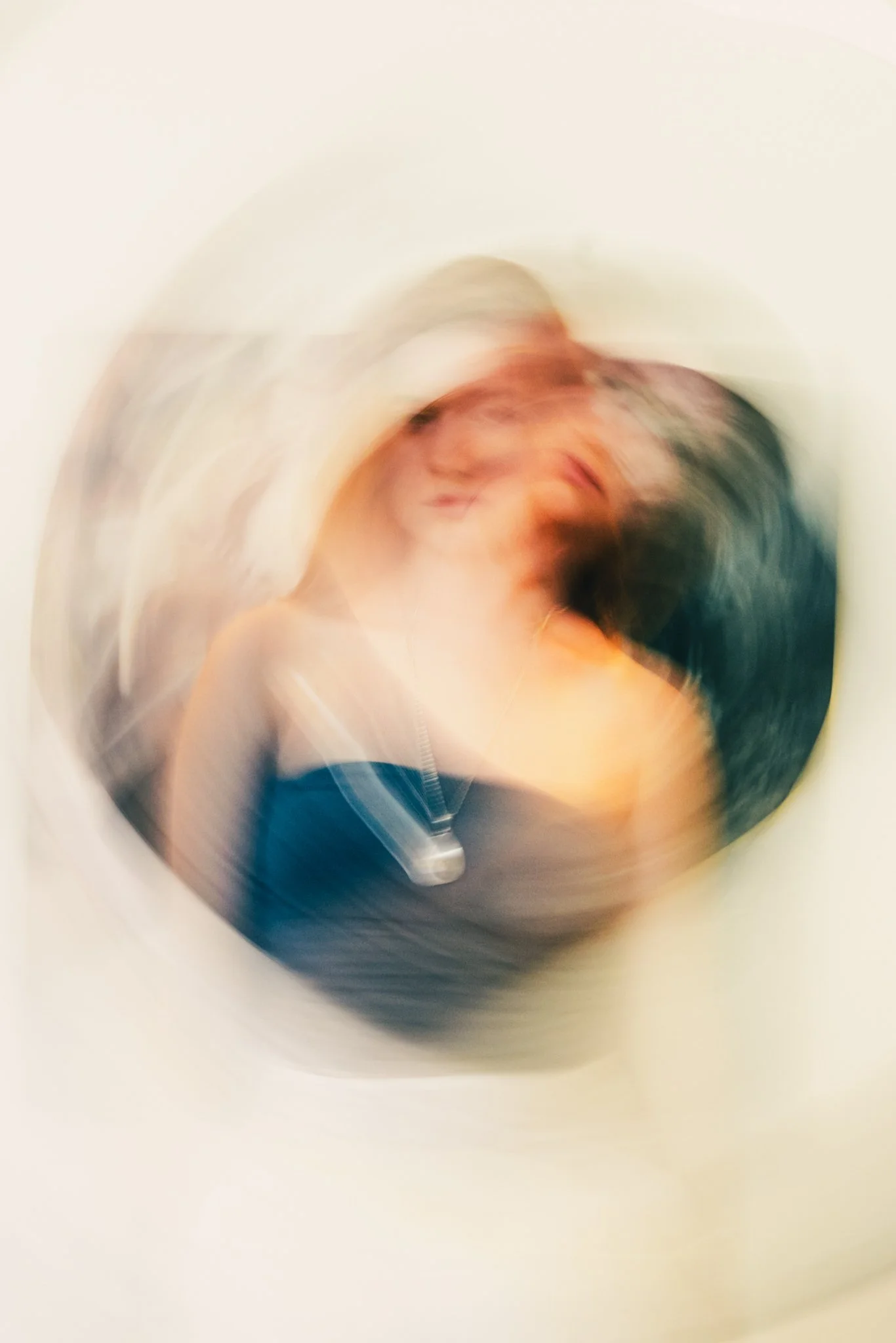 Blurred image of a woman with a dog on her shoulder, with a white background.