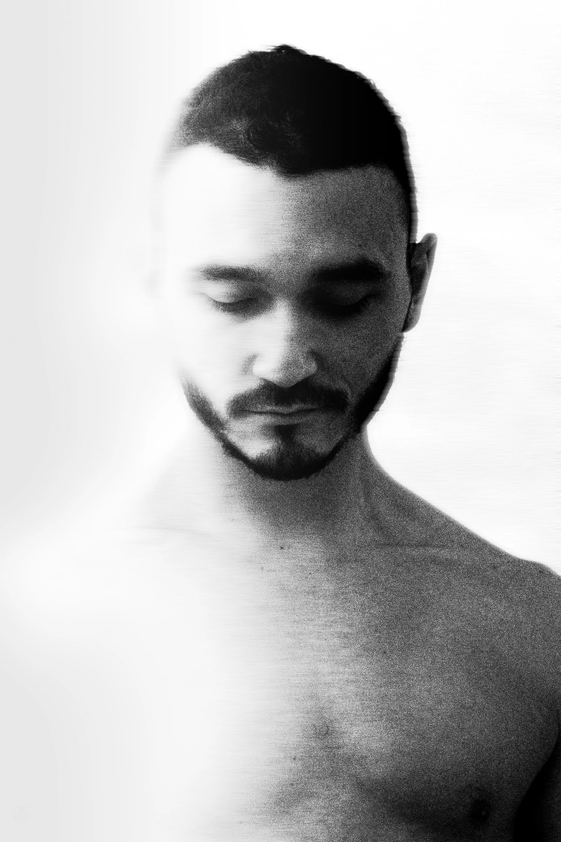 Black and white portrait of a shirtless man with closed eyes and a slight smile, facing slightly downward.