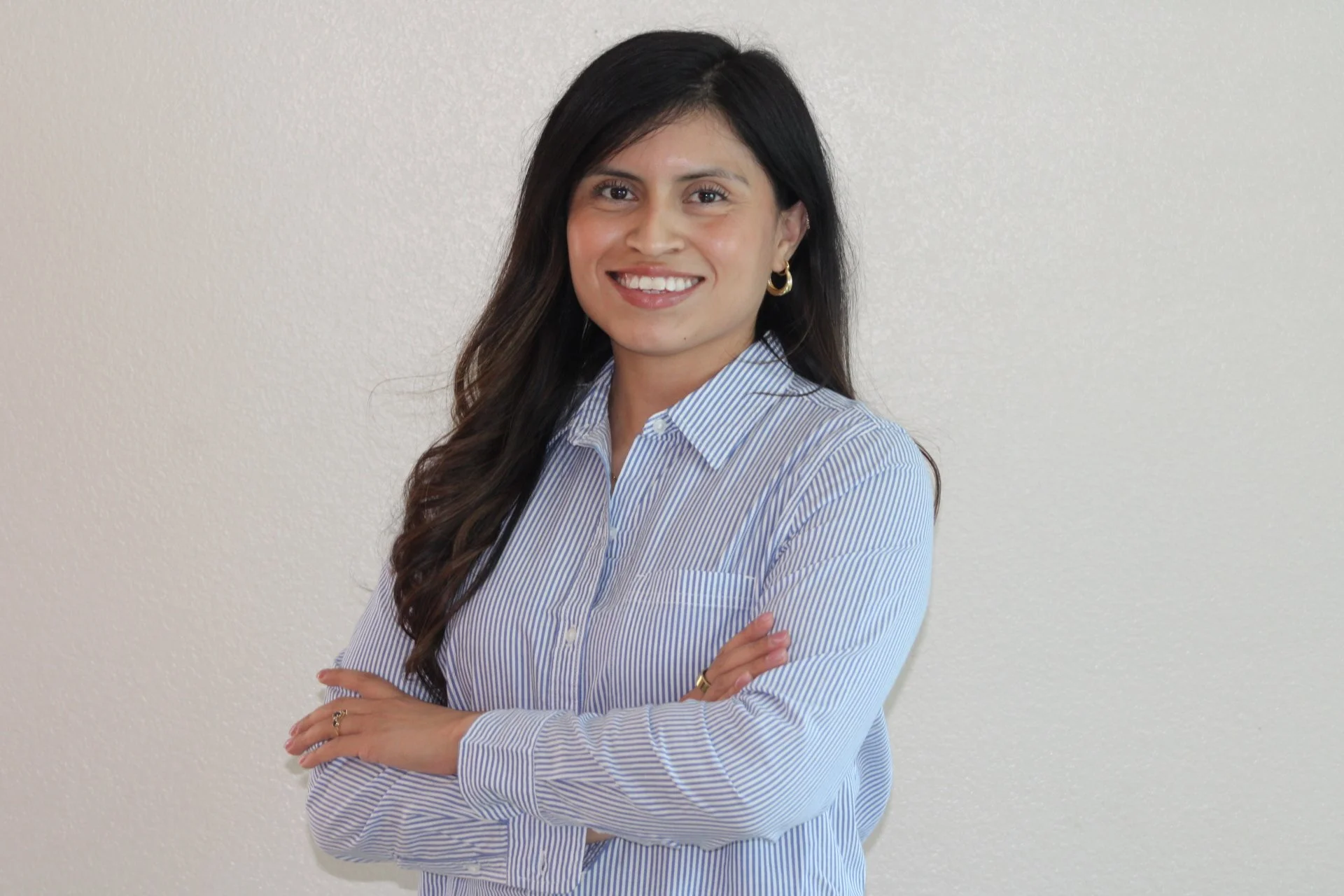Hispanic EMDR therapist with standing with her arms crossed