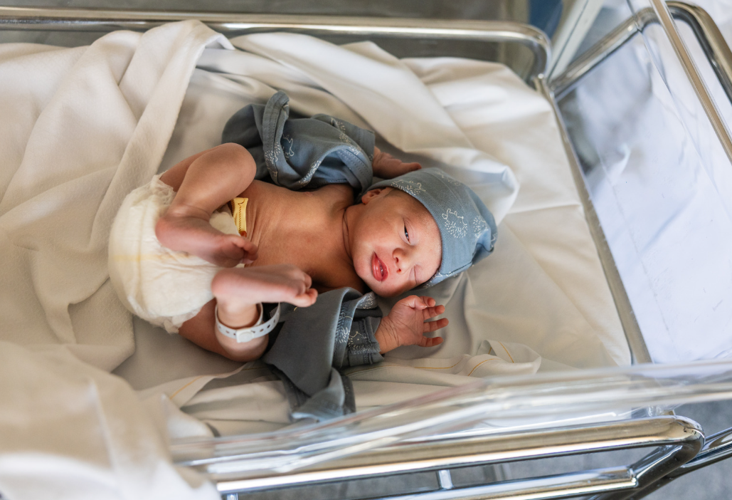 Newborn baby laying in the hospital bed