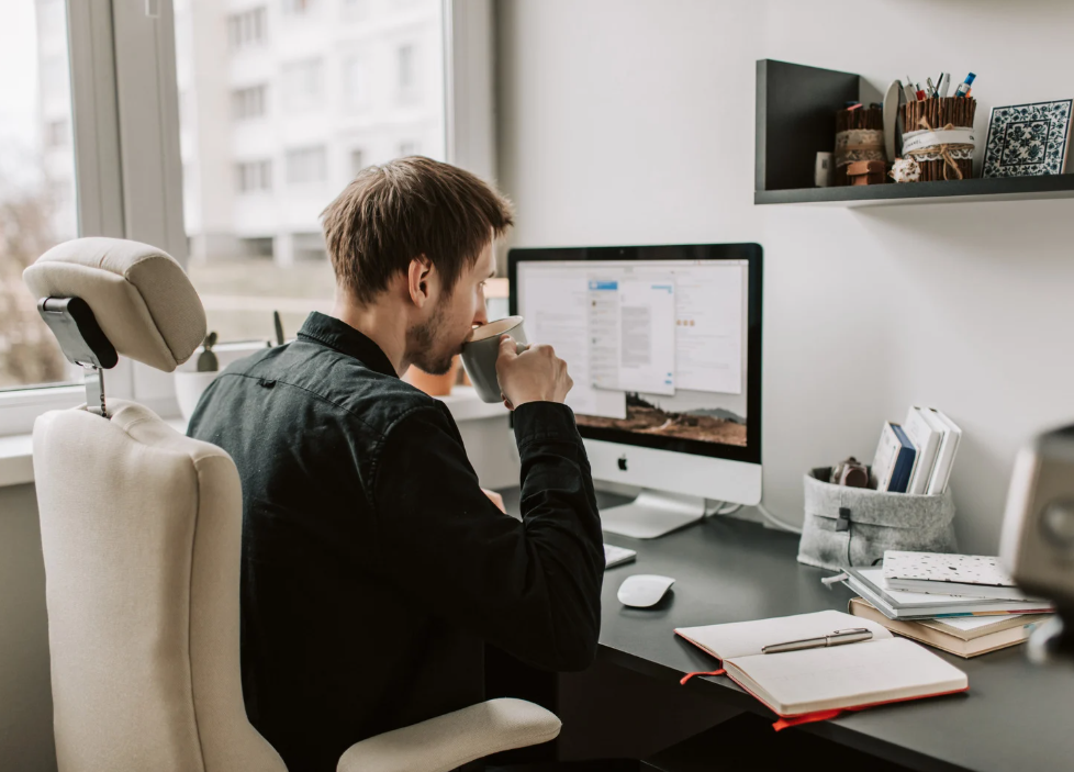 Man sitting at his desk drinking coffee