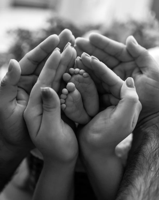 Tiny baby feet held by parents hands