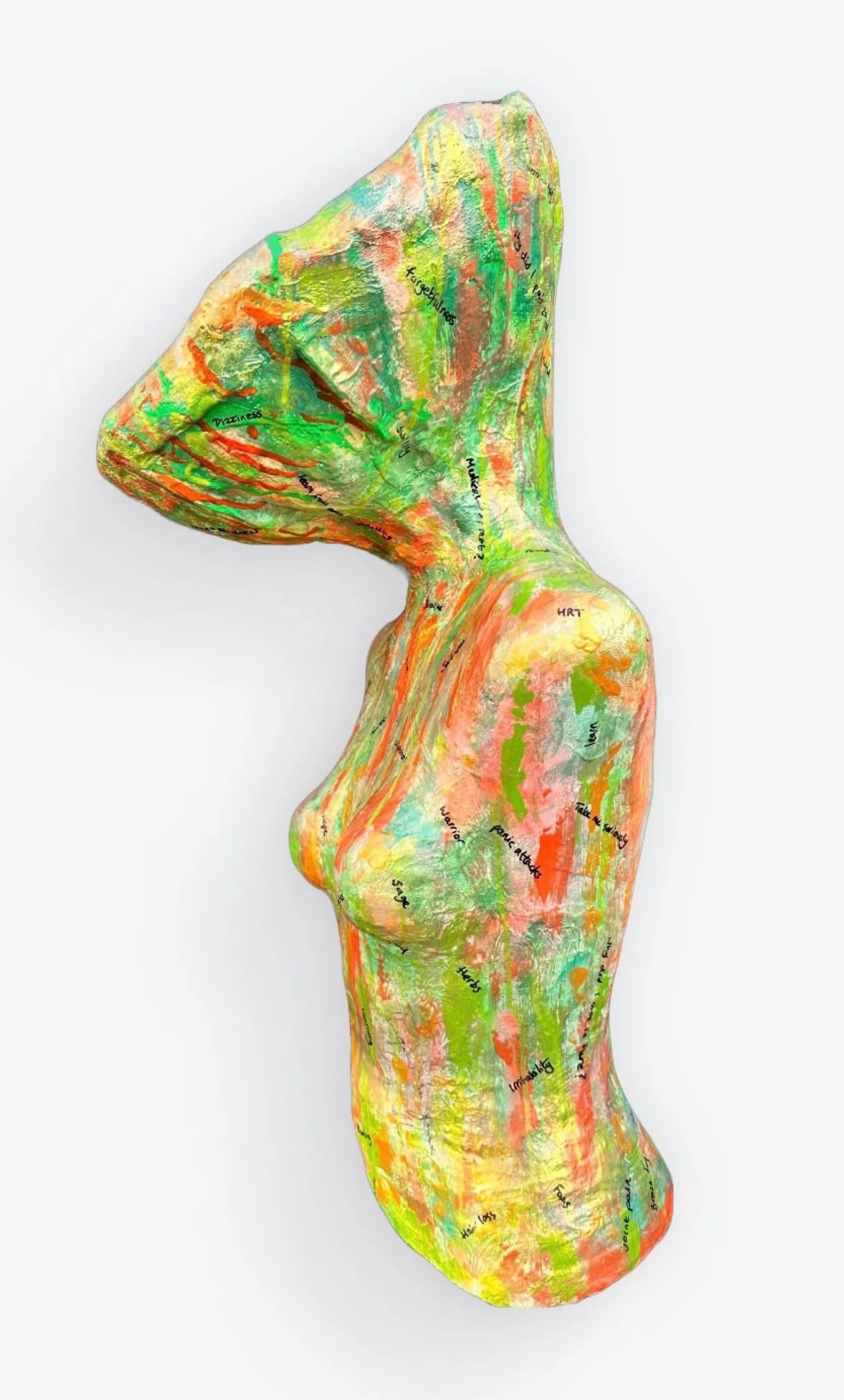 side view of meno brain menopausal sculpture with bright green orange peach and gold paint drips and menopausal text over the body and the exaggerated large head