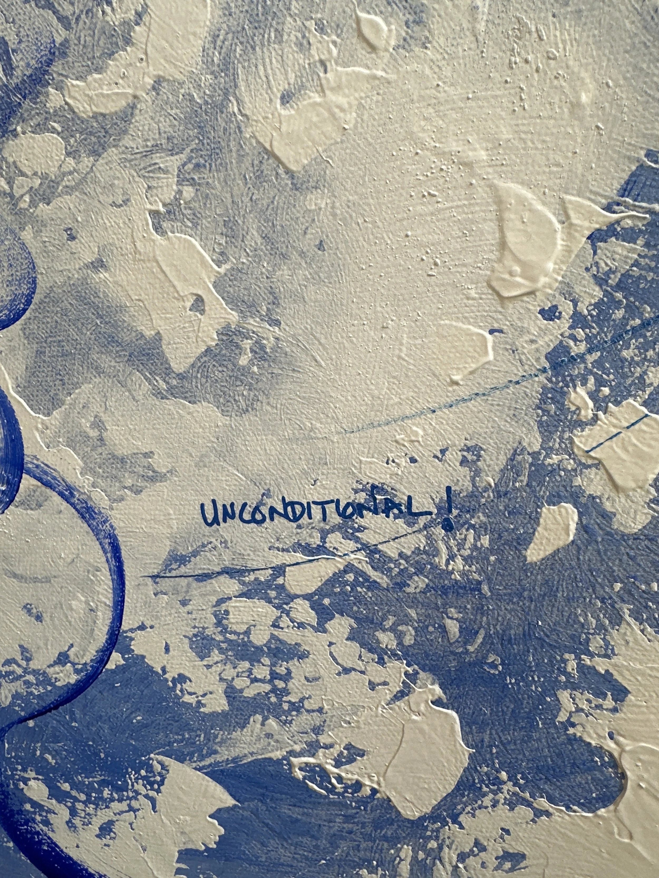 Close up of blue and white canvas painting, with textured paint and the words 'unconditional!' written on the surface