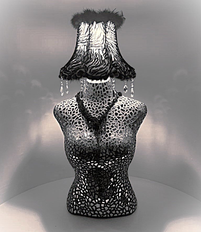 Final bust sculpture adorned with mirror glass, black beaded necklace and flamboyant zebra pint lampshade, this is a black and white photograph so the pompoms look black in the shot. Crystal droplets hang from the bottom of the shade.