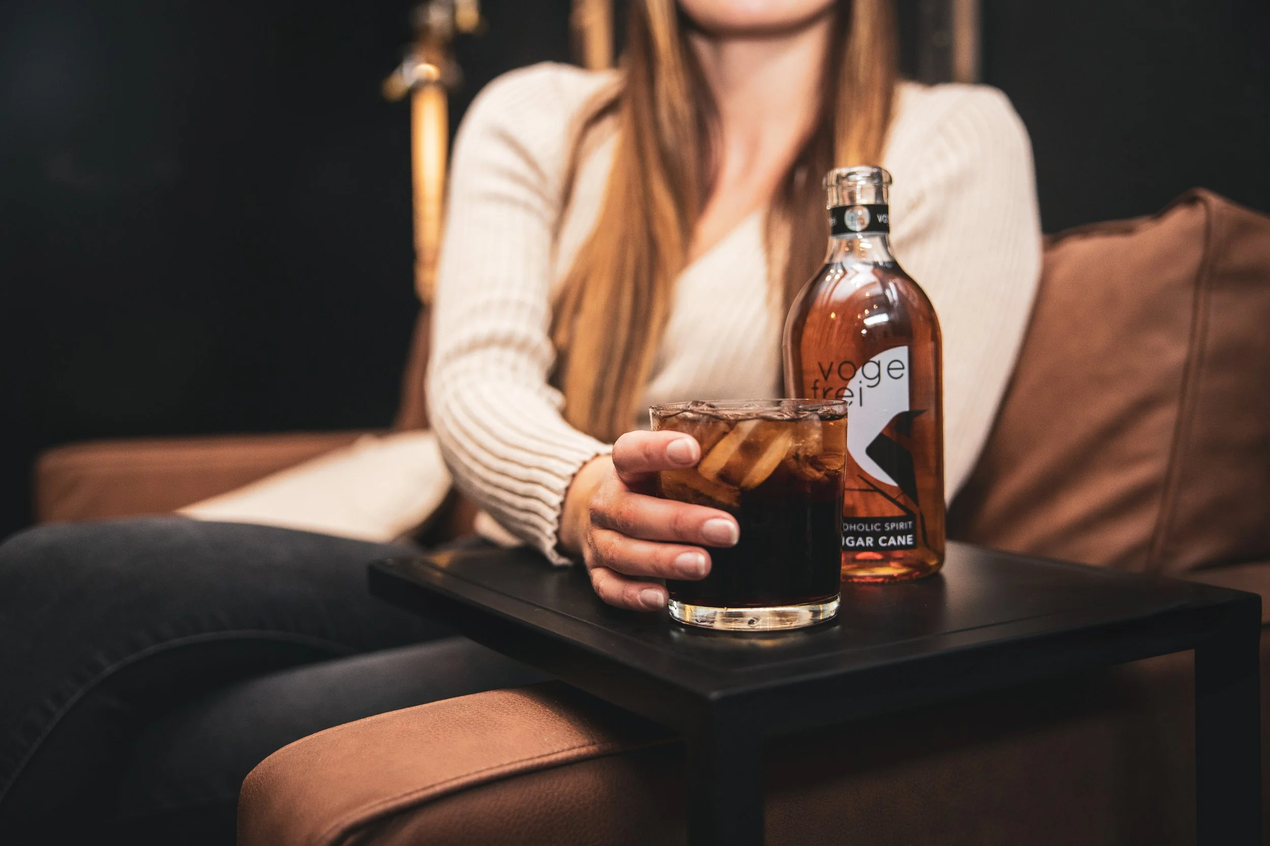 A woman holding a glass of alcoholfree rum cola