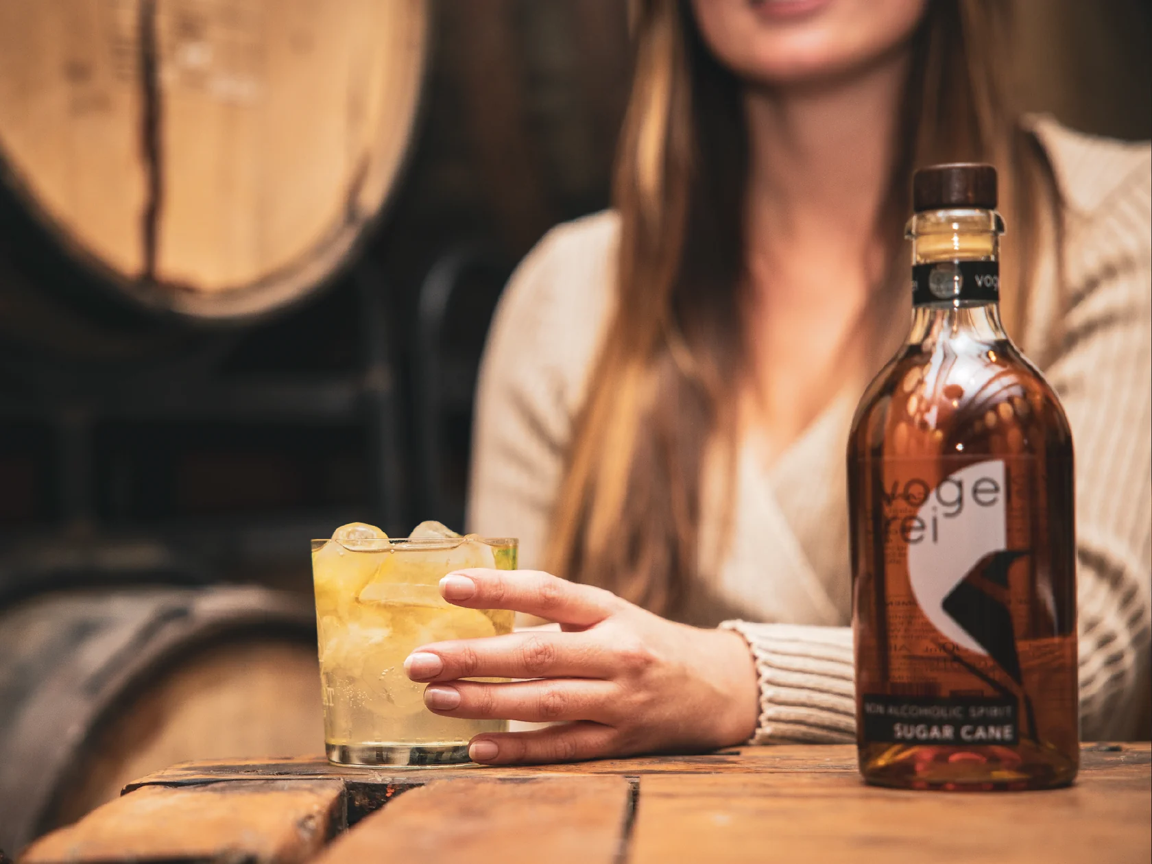 A woman holding a glass of an alcoholfree Dark and Stormy