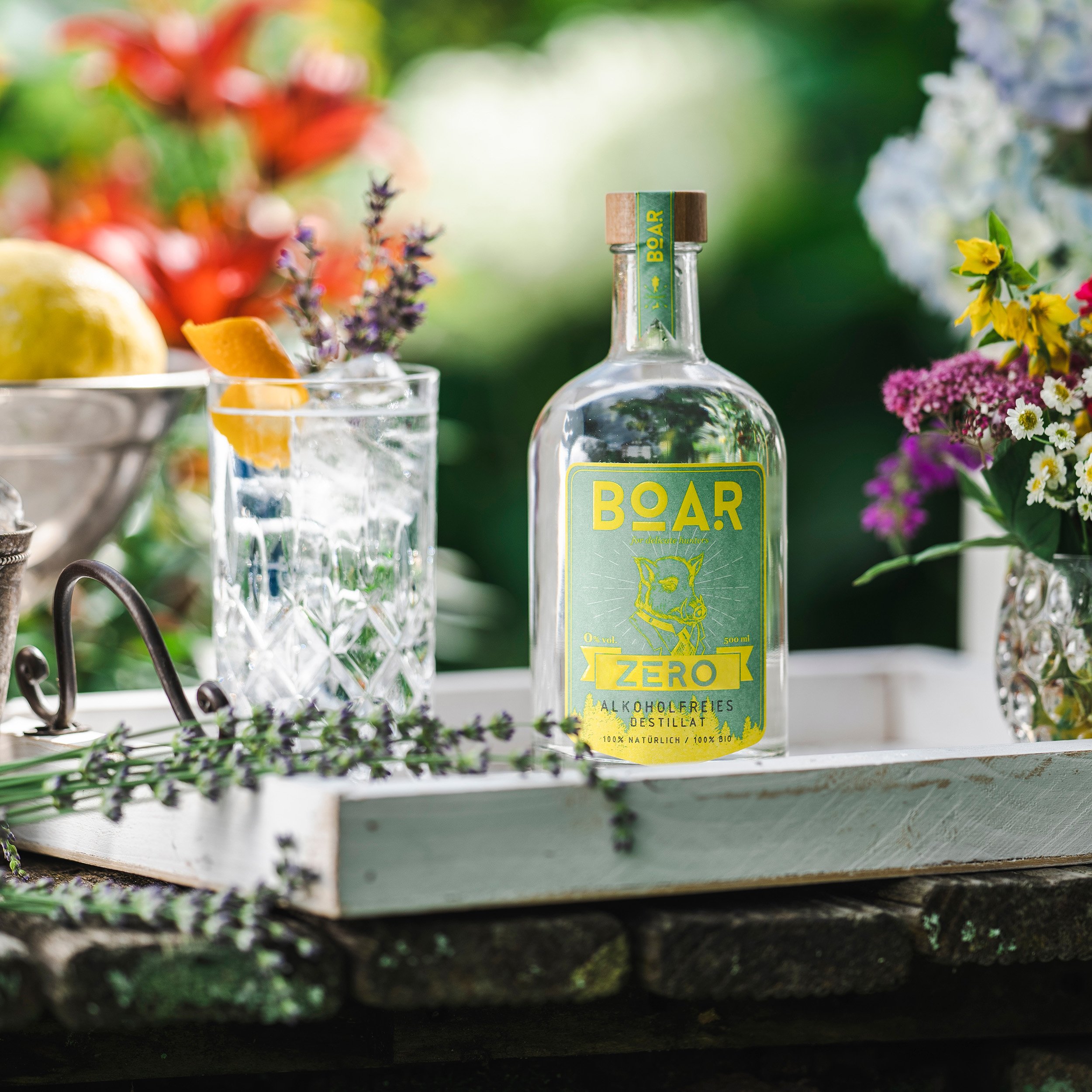 A bottle of non-alcoholic gin standing on the counter with a glass mixed gin and tonic.
