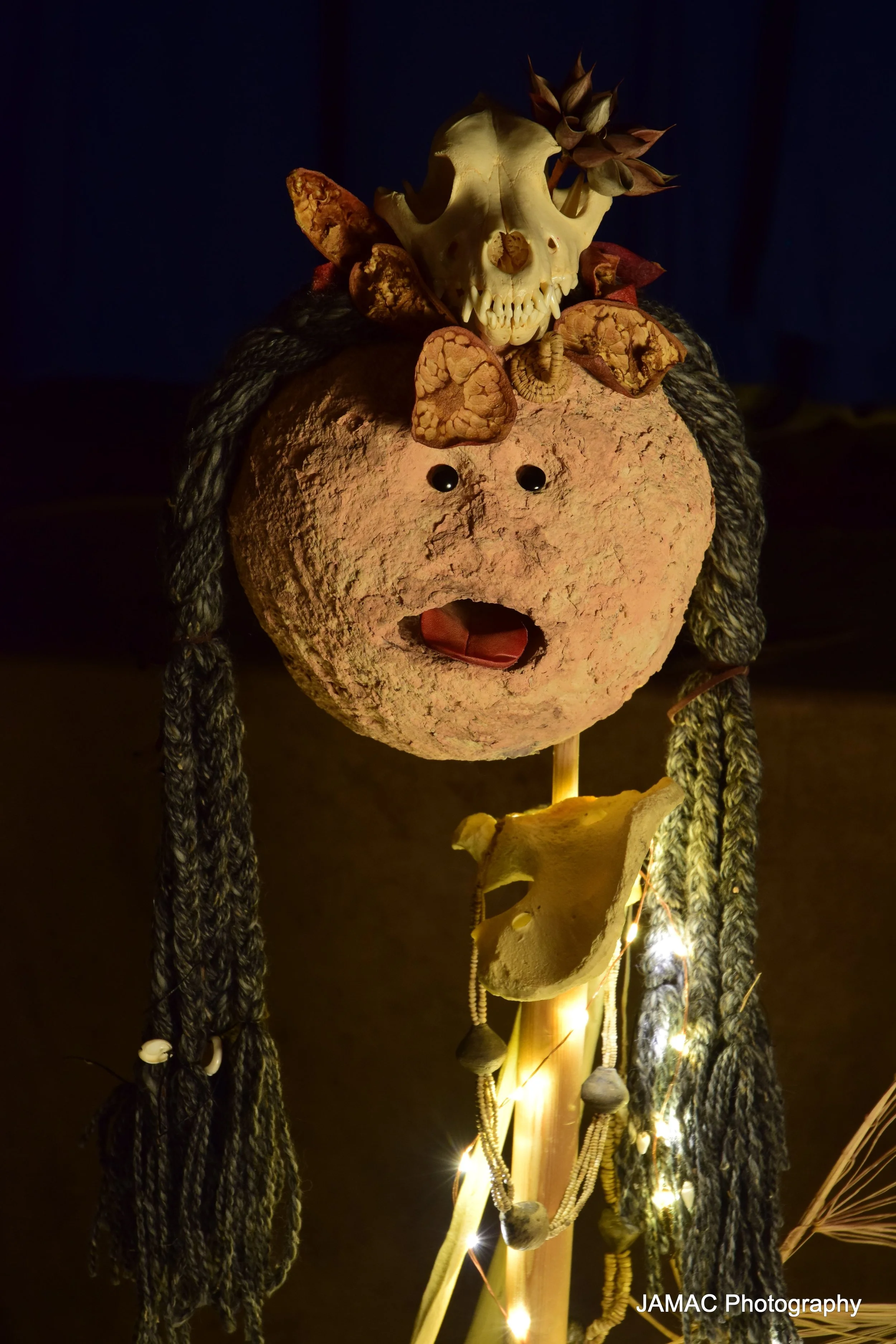 Puppet with a beige face and a coyote skull headdress