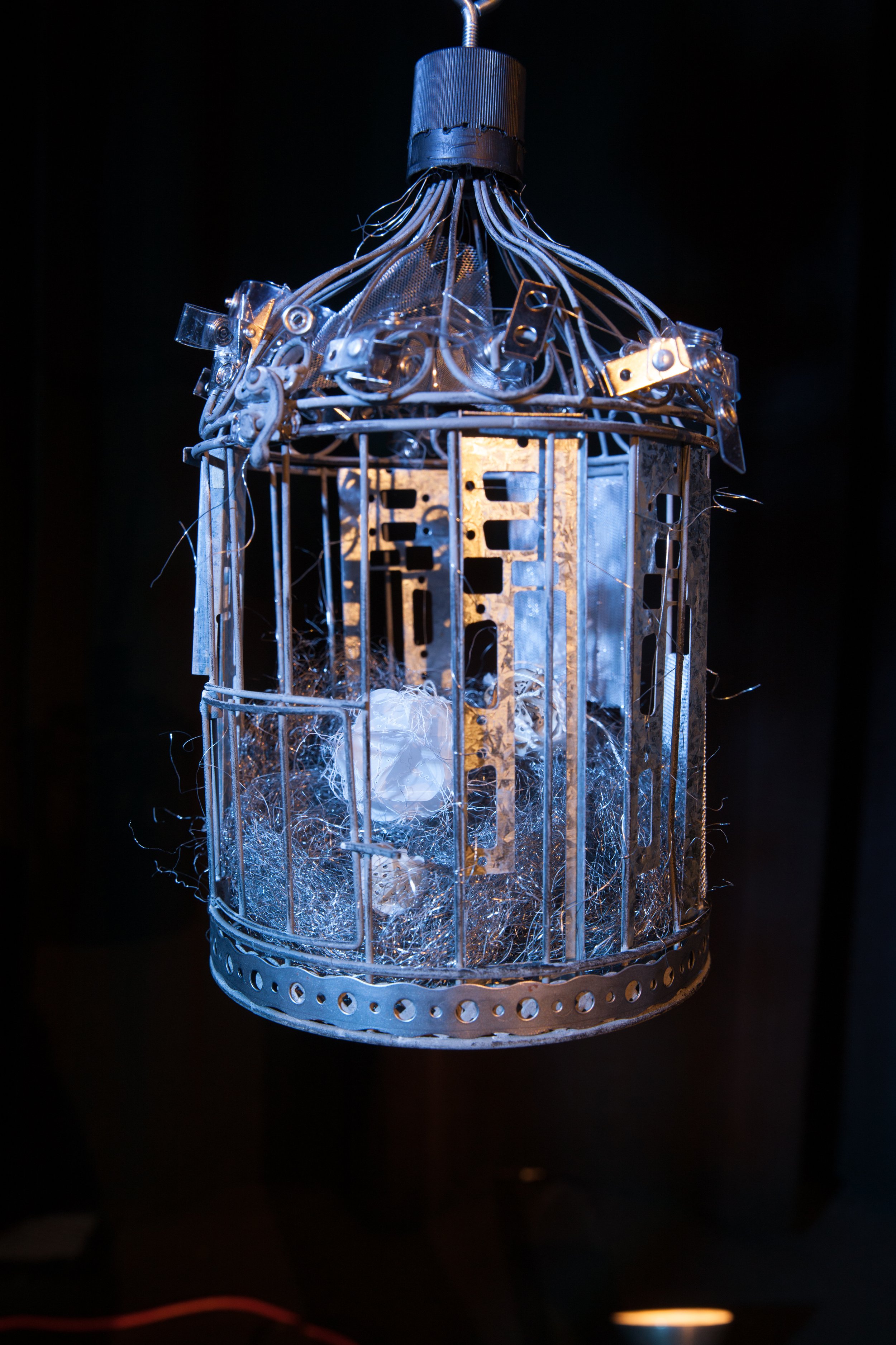 bird cage with metal decorations and puppet orb inside 