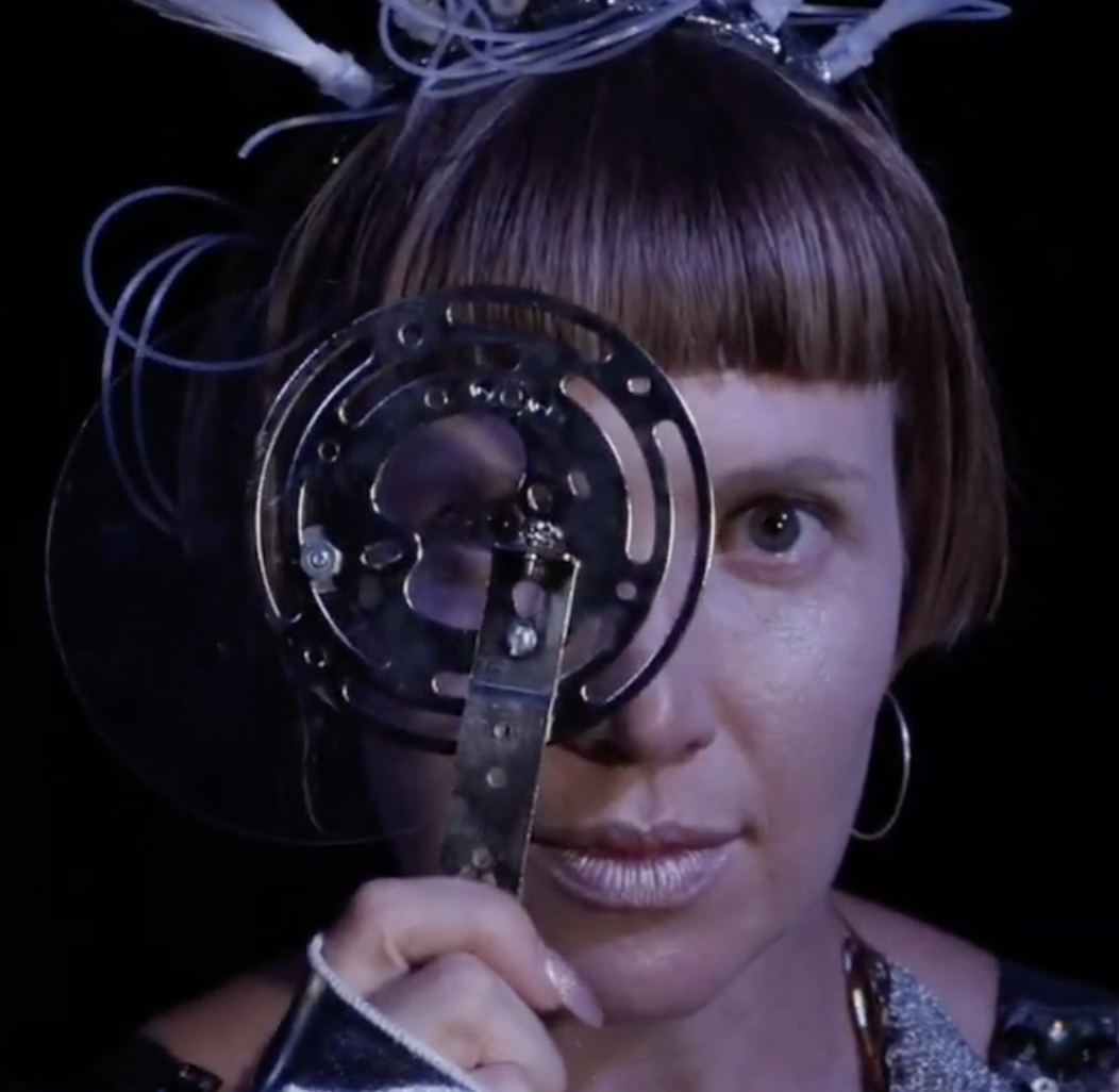 Woman stares intently through a steam punk magnifying glass 