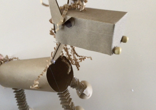 A homemade puppet horse made from cardboard, paper towel rolls, and various craft materials with googly eyes.