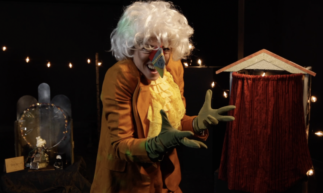 Person wearing a Amadeus white wig in a yellow jacket and green gloves 