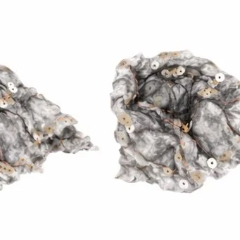grey and white textile object with a few sequins 