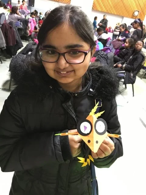 Young Girl holds onto a folded bird puppet 