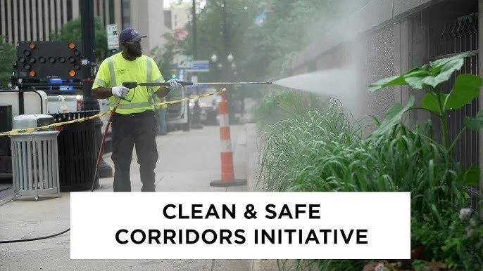 Worker power washing a fence