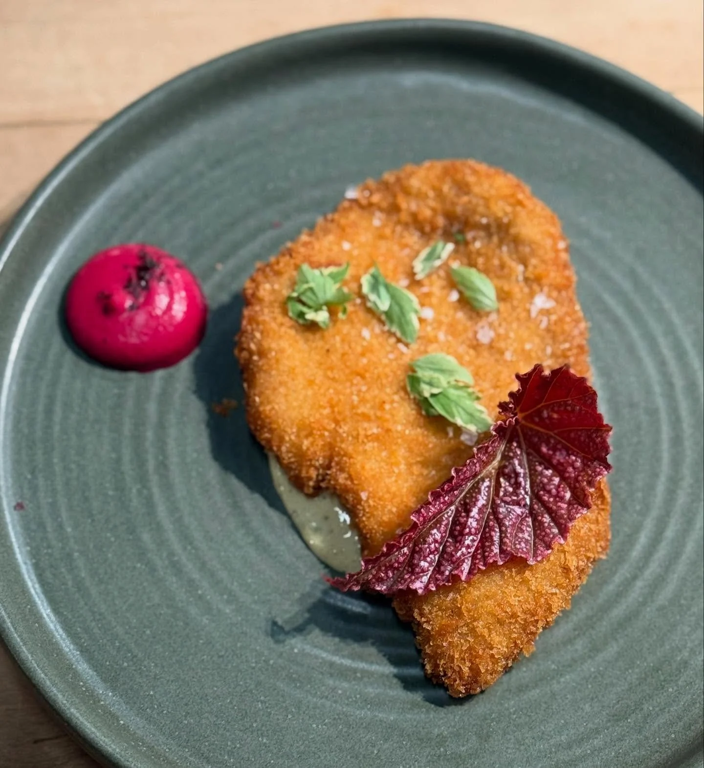 Pork schnitzel atop a soy sauce, pickle Remoulade. Smoked beet and fermented chili on the side.