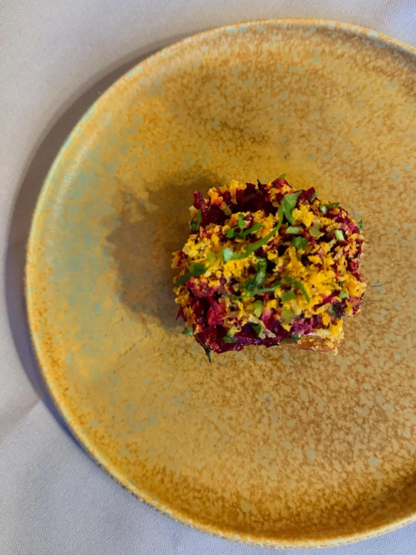 Root vegetable tartar on red fife brioche.  Finished with smoked kewpi and cured egg yolk.