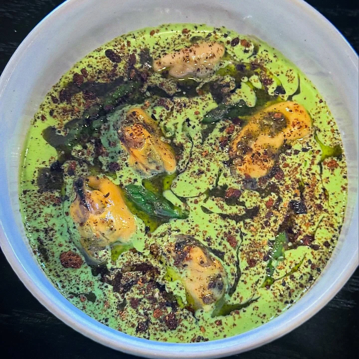 This is an almost mosaic dish of gazpacho made of cucumber and green garlic, filled with asparagus and chilled mussels marinated in lemon pressed olive oil.  It is finished with burnt bread and a salsa macha made of sesame seeds and pistachio.  On th