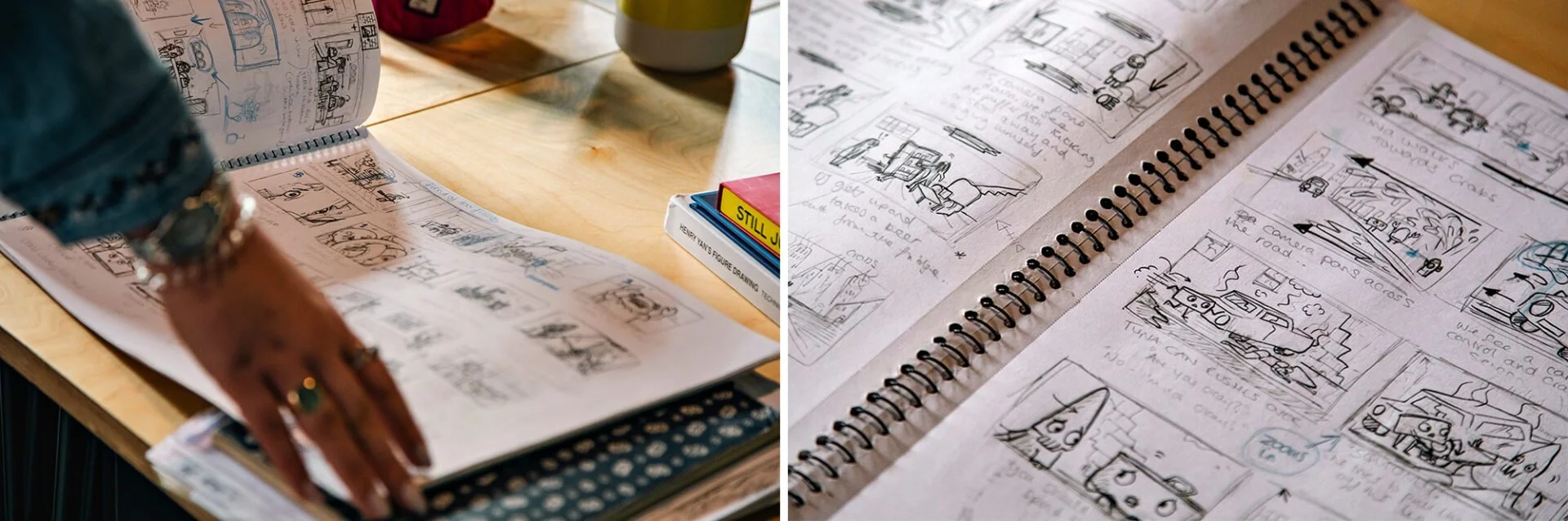 Spiral-bound sketchbook with comic sketches and notes on a table, with a person's hand pointing at the sketches. The sketches include cars and various scenes, with handwritten annotations.