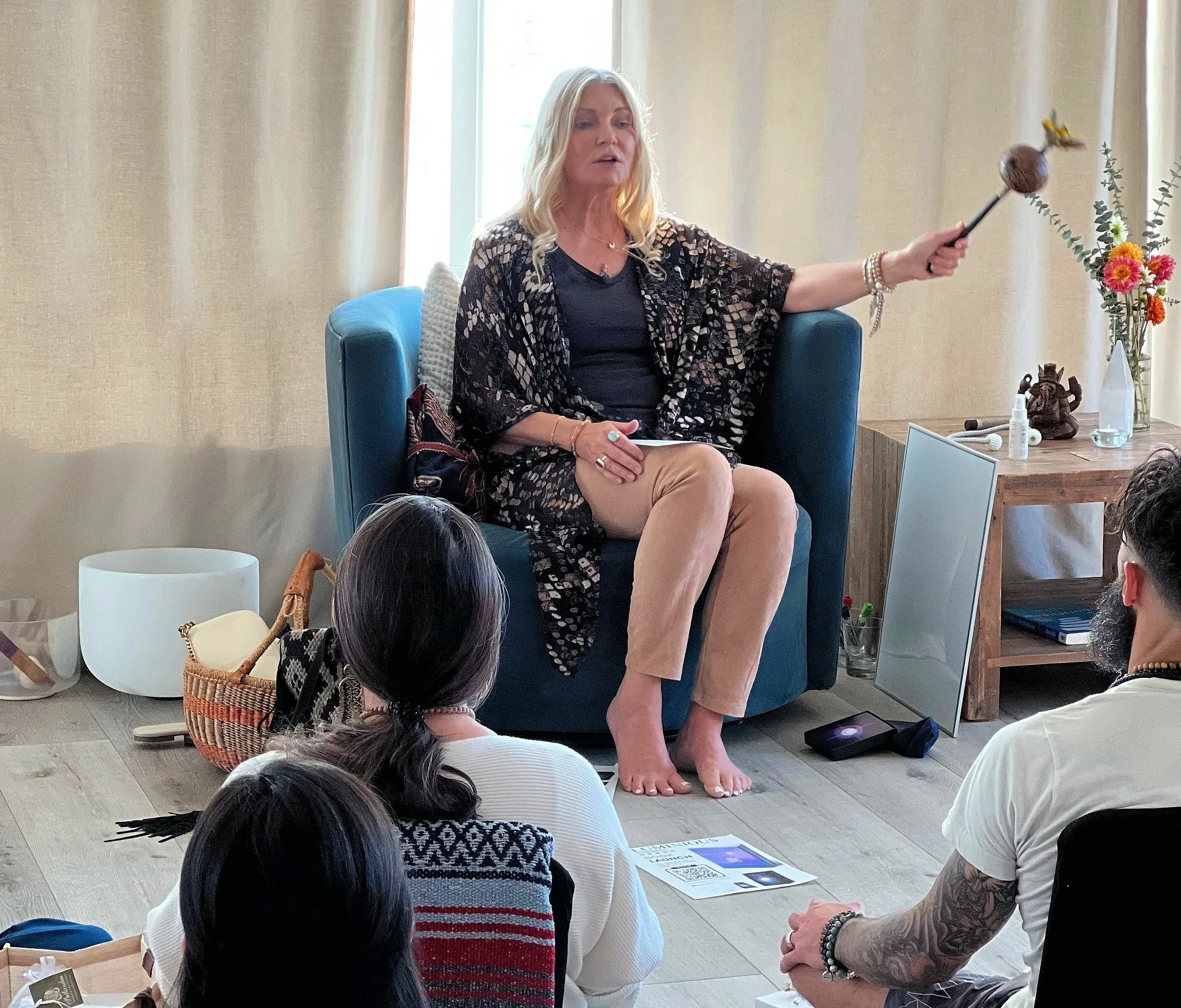 Patty in front of classroom teaching energy medicine to class with rattle.