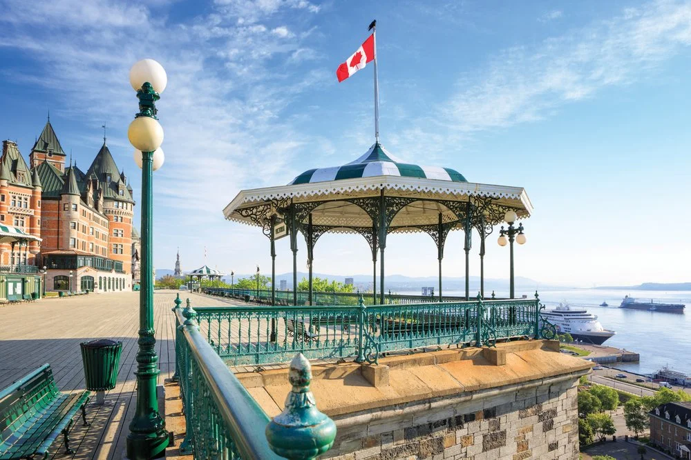 Vélum ornant un kiosque en fer forgé sur un quai en bord de mer, avec un drapeau canadien flottant, à Québec, au Canada.