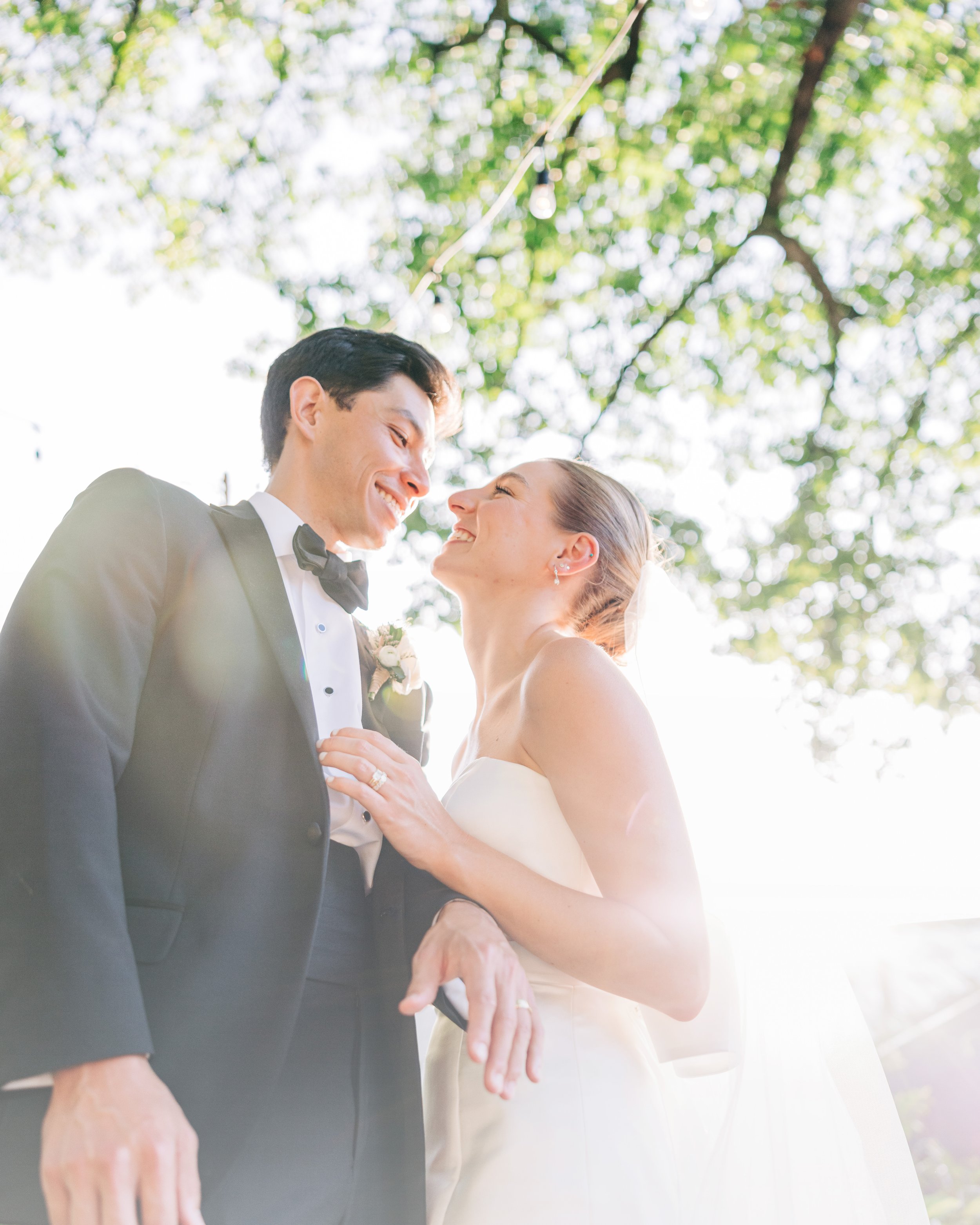 bride and groom smiling at each other under trees during baton rouge wedding photography