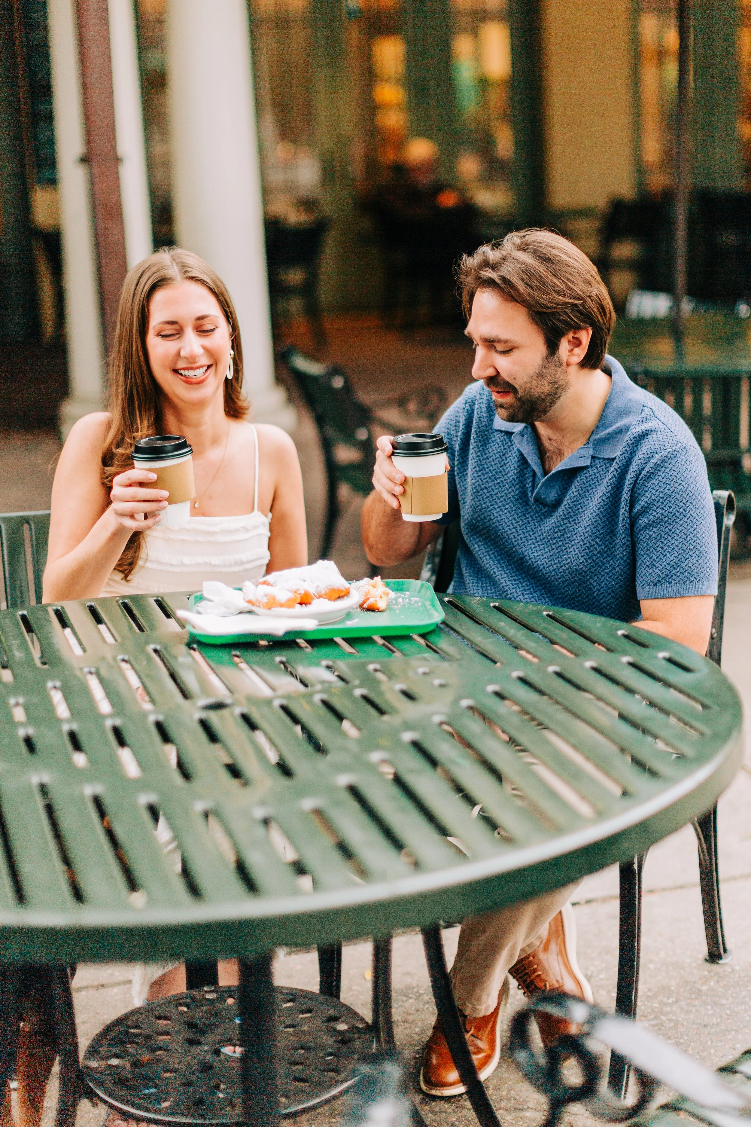 couple having coffee at cafe du monde during engagement photography with sarah shaw