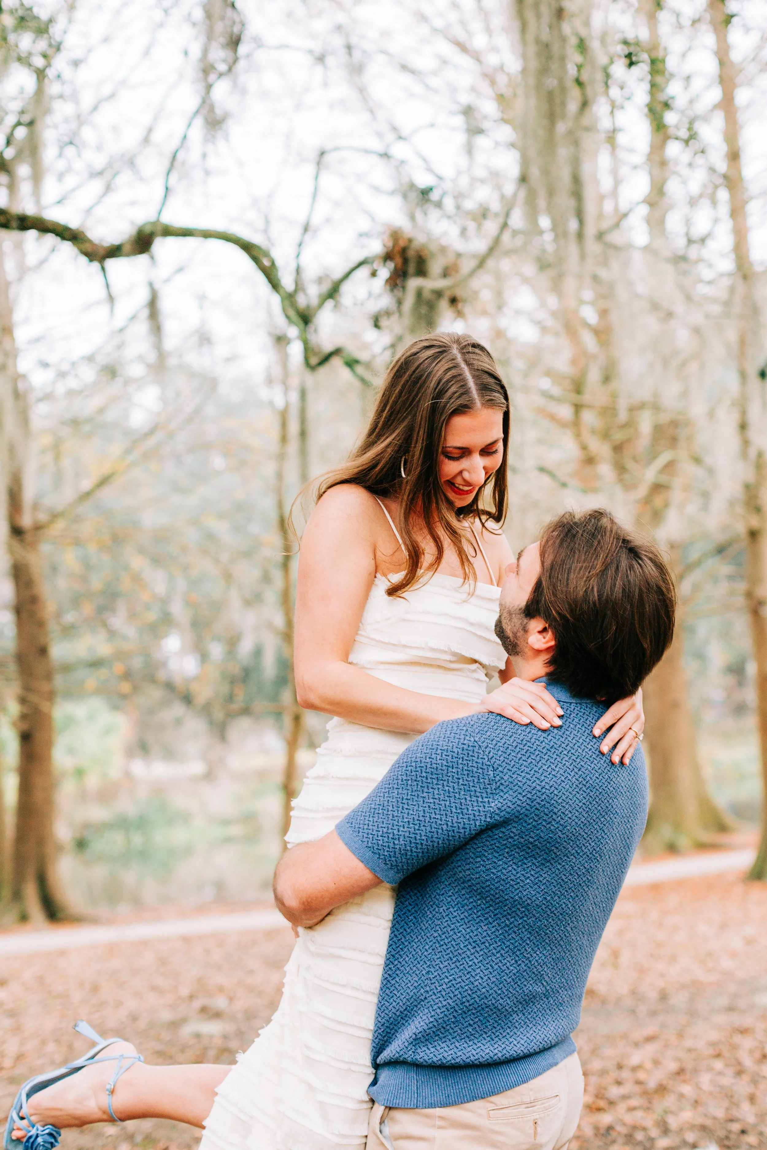 victoria and patrick’s new orleans city park engagement photos, man lifting woman off the ground in city park, baton rouge wedding photography