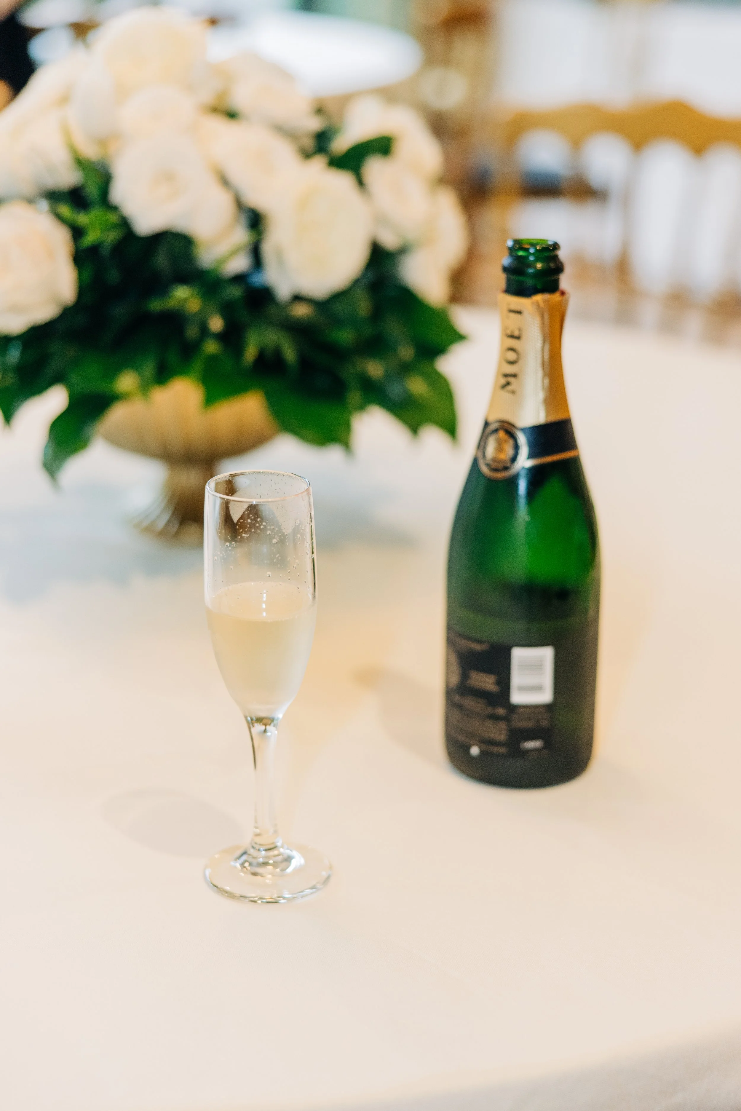 champagne glass and champagne bottle on the table with flowers in the neptune at houmas house baton rouge, houmas house wedding photography, baton rouge wedding photography,