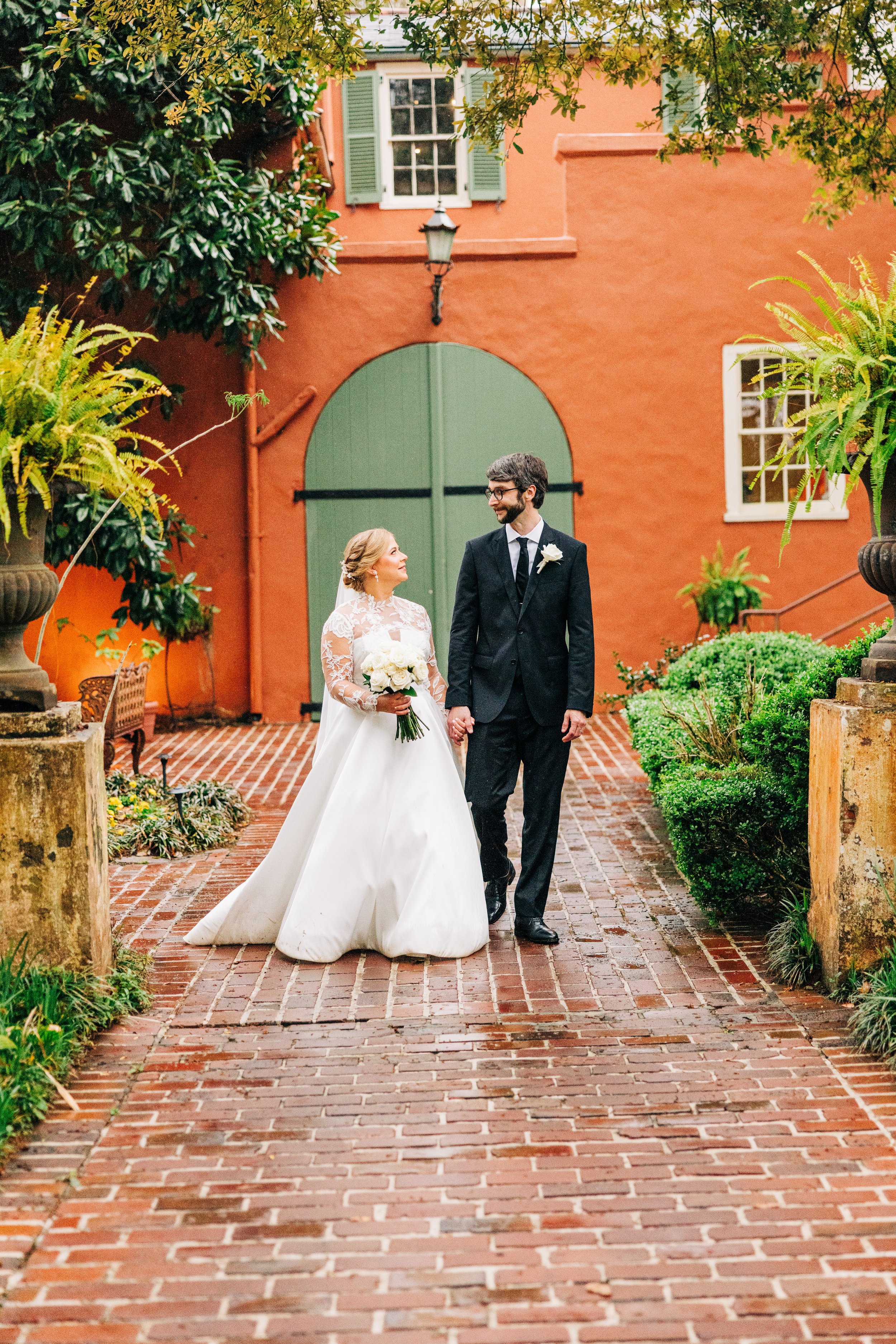 bride and groom portraits at houmas house baton rouge, bride and groom smile at each other walking hand in hand, baton rouge wedding photography