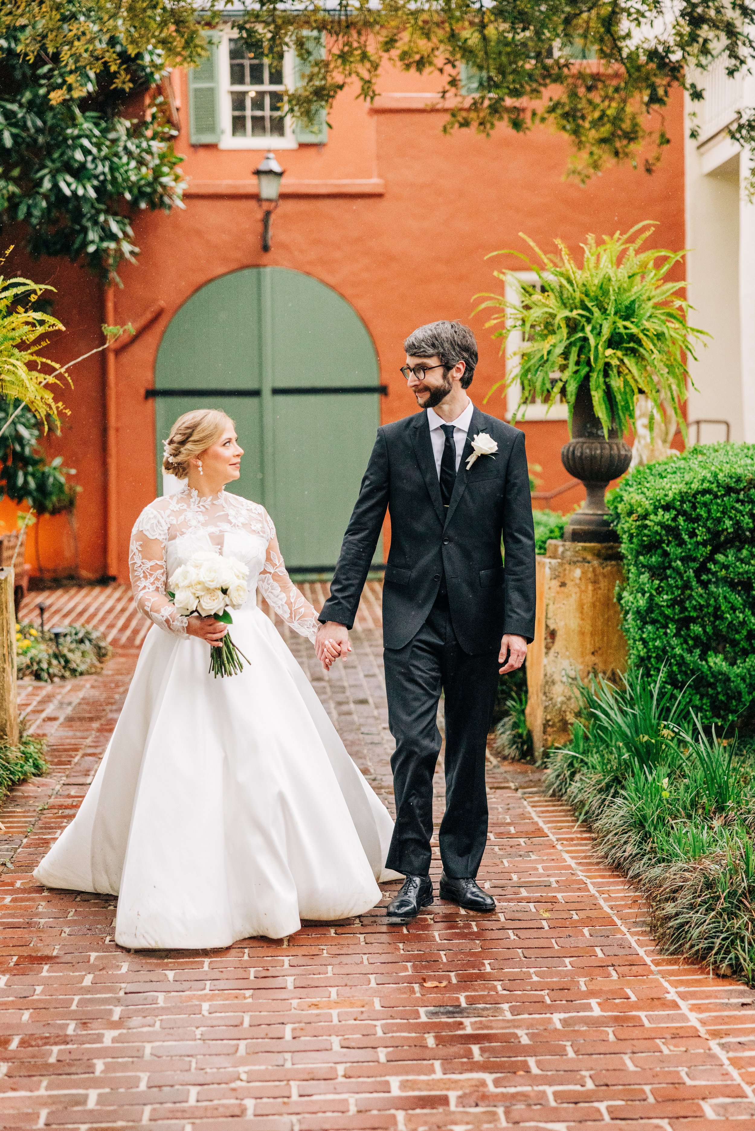 bride and groom portraits at houmas house baton rouge, bride and groom smile at each other walking hand in hand, baton rouge wedding photography