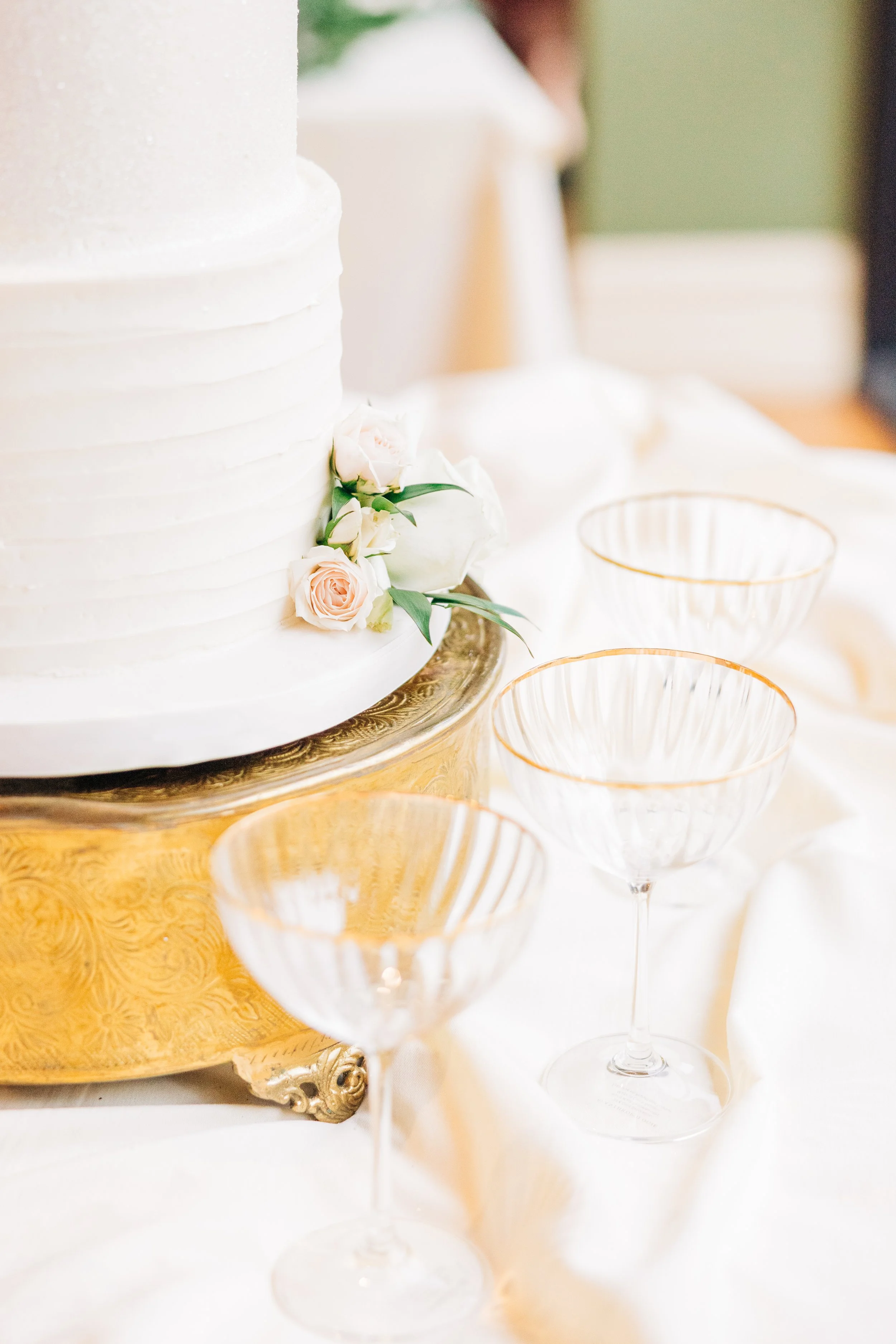 champagne glasses on table with white 3 tiered wedding cake, white flowers on wedding cake, houmas house wedding receptions, baton rouge wedding photography
