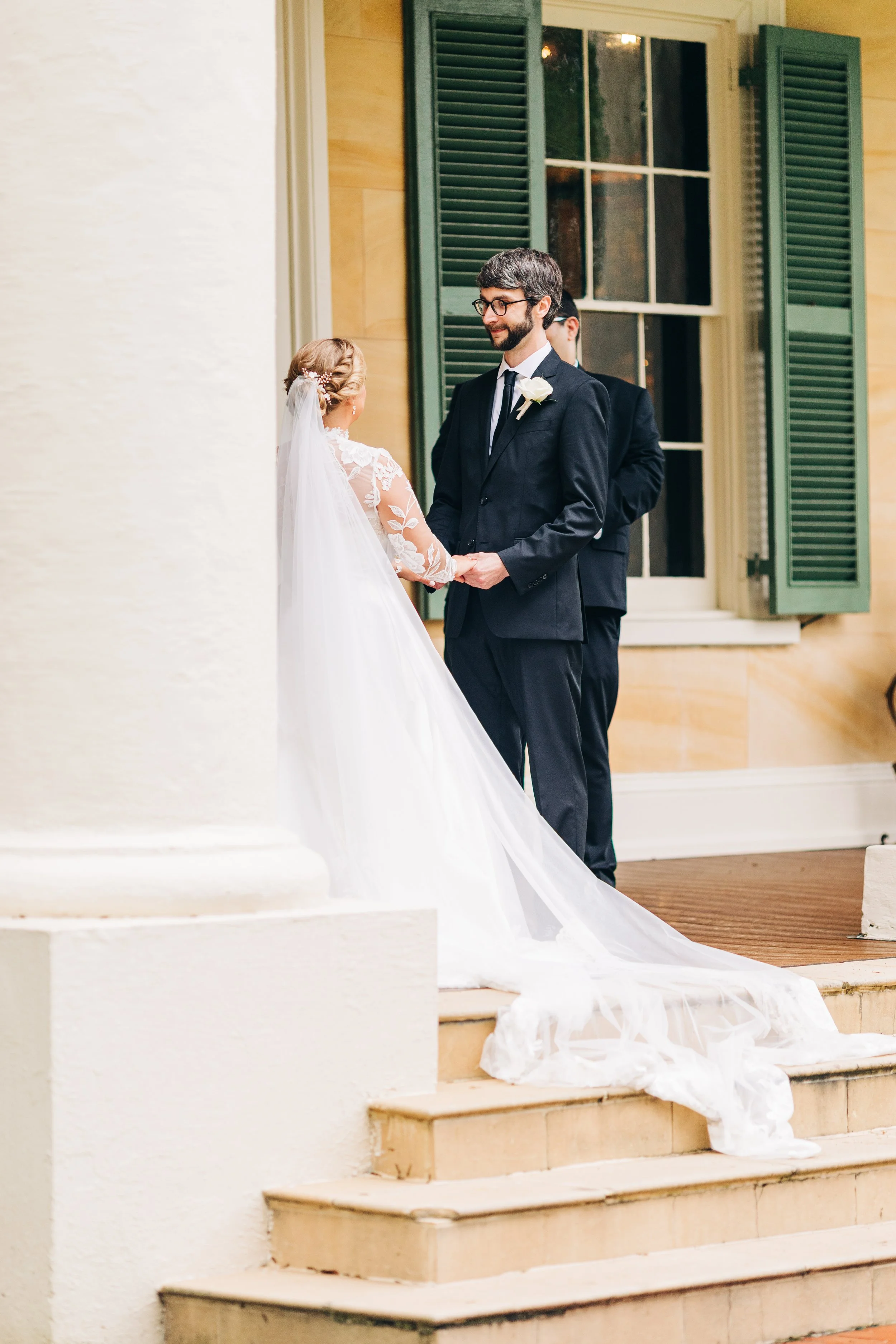 bride and groom on the front porch of houmas house during outdoor wedding ceremony in spring, exchanging vows, baton rouge wedding photography