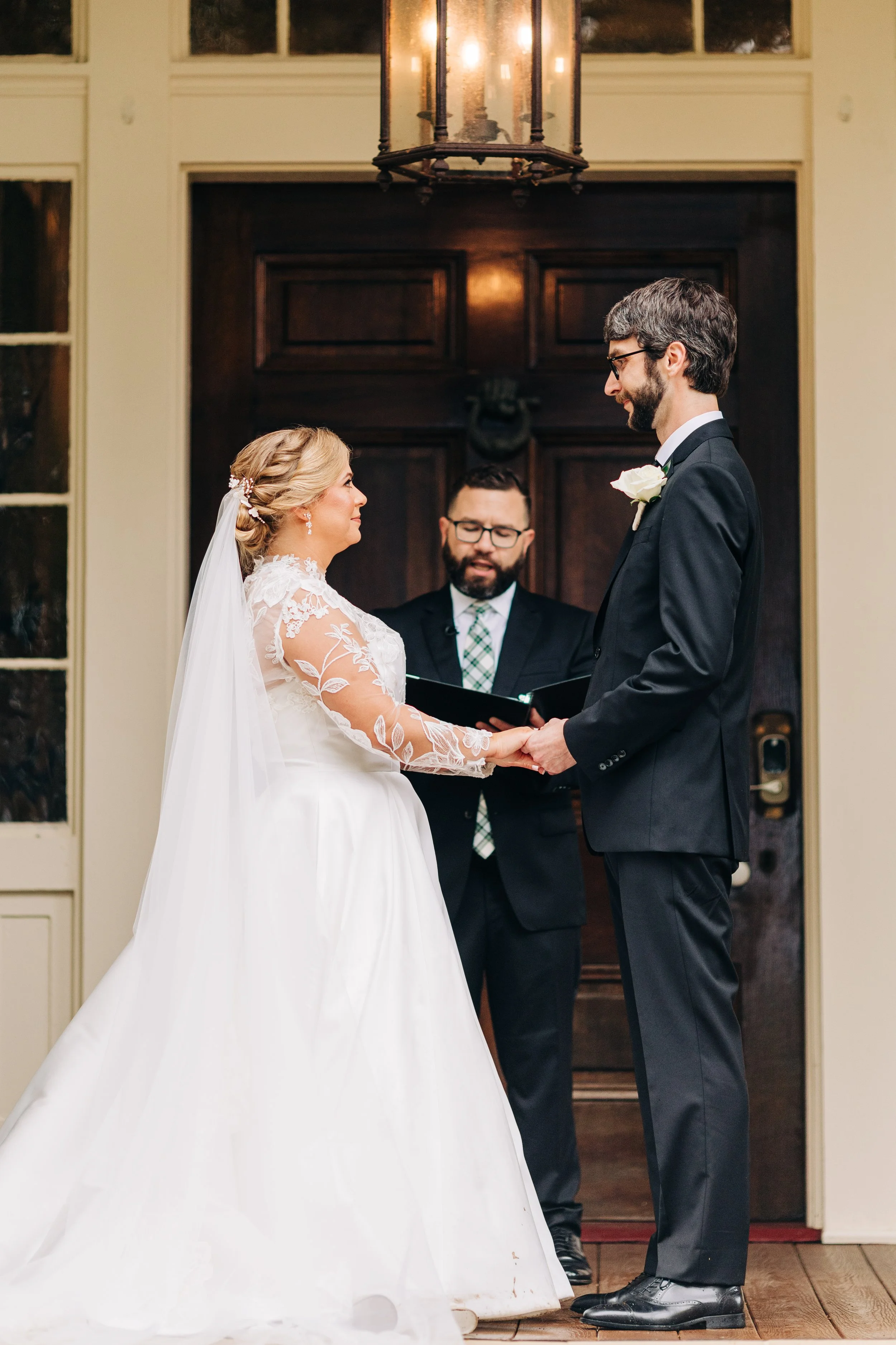 bride and groom on the front porch of houmas house during outdoor wedding ceremony in spring, exchanging vows, baton rouge wedding photography