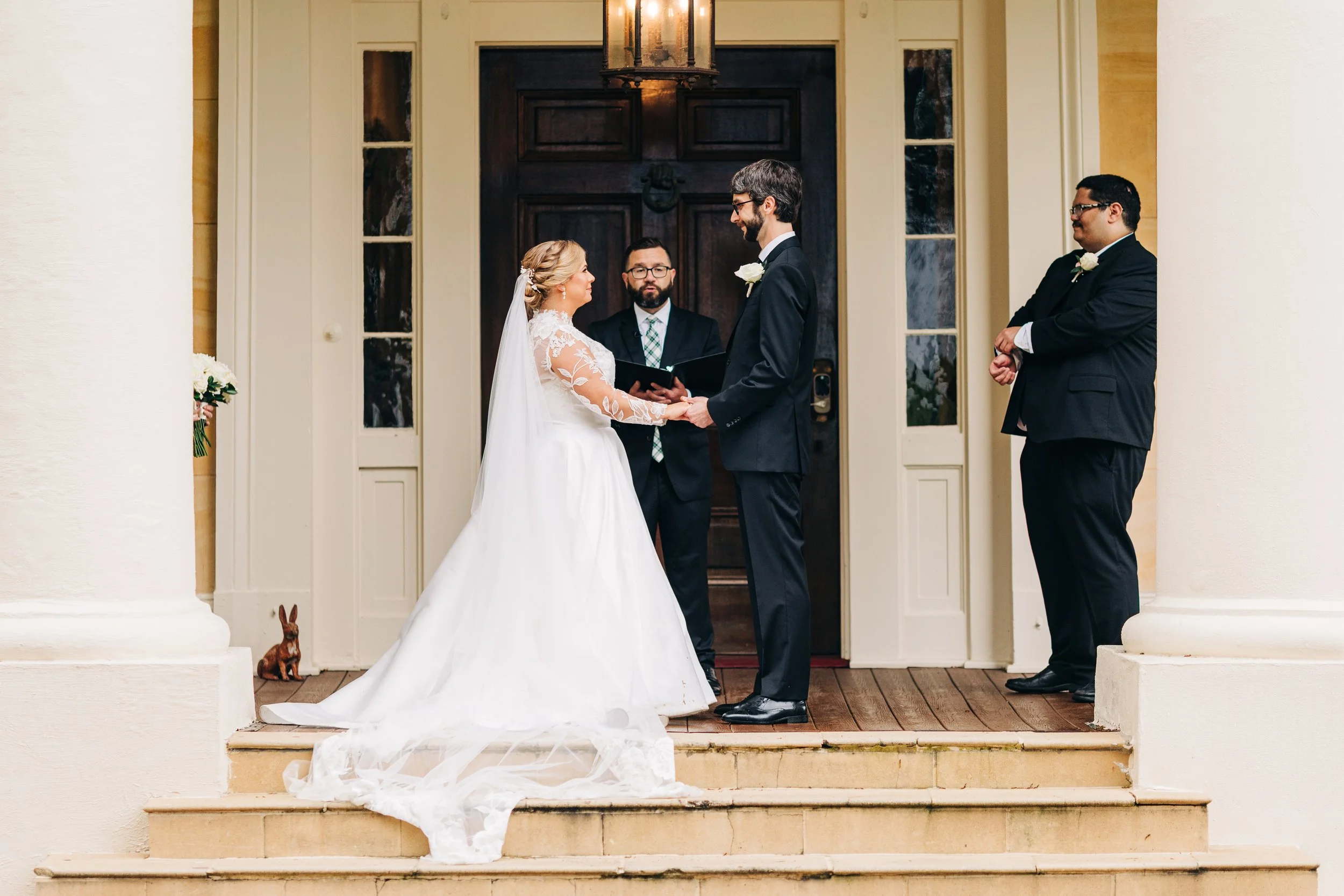bride and groom on the front porch of houmas house during outdoor wedding ceremony in spring, exchanging vows, baton rouge wedding photography