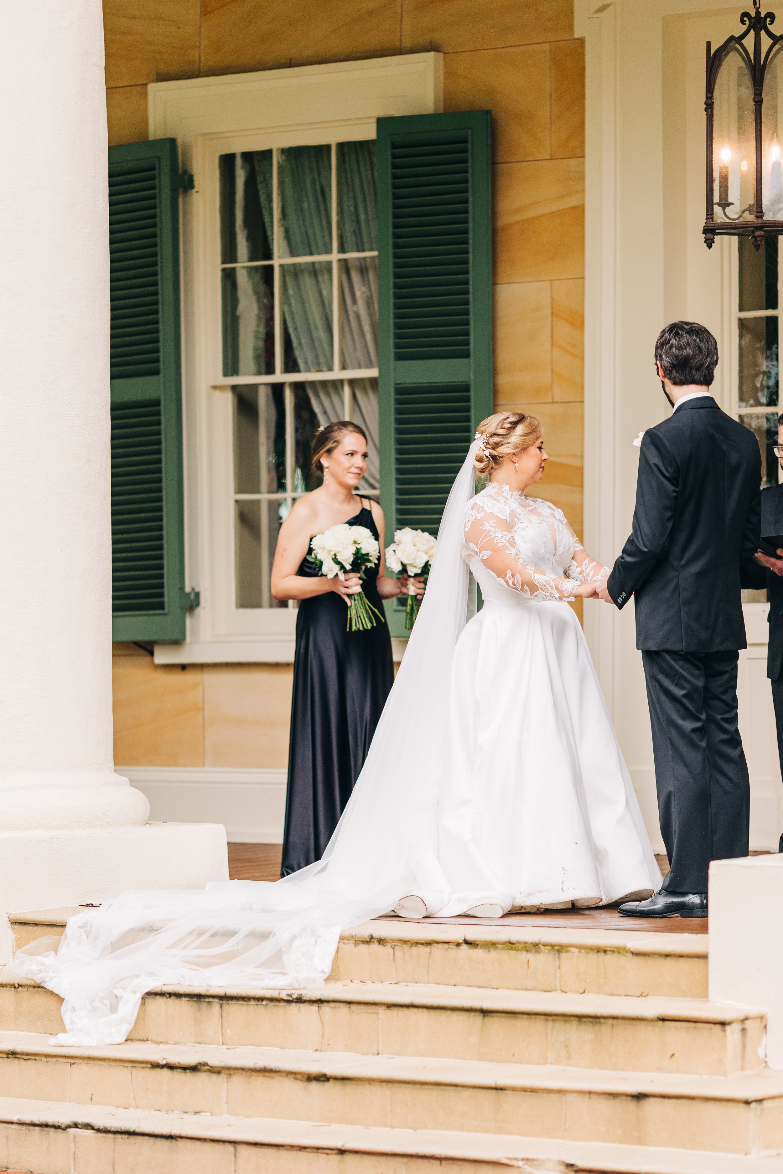 bride and groom on the front porch of houmas house during outdoor wedding ceremony in spring, exchanging vows, baton rouge wedding photography