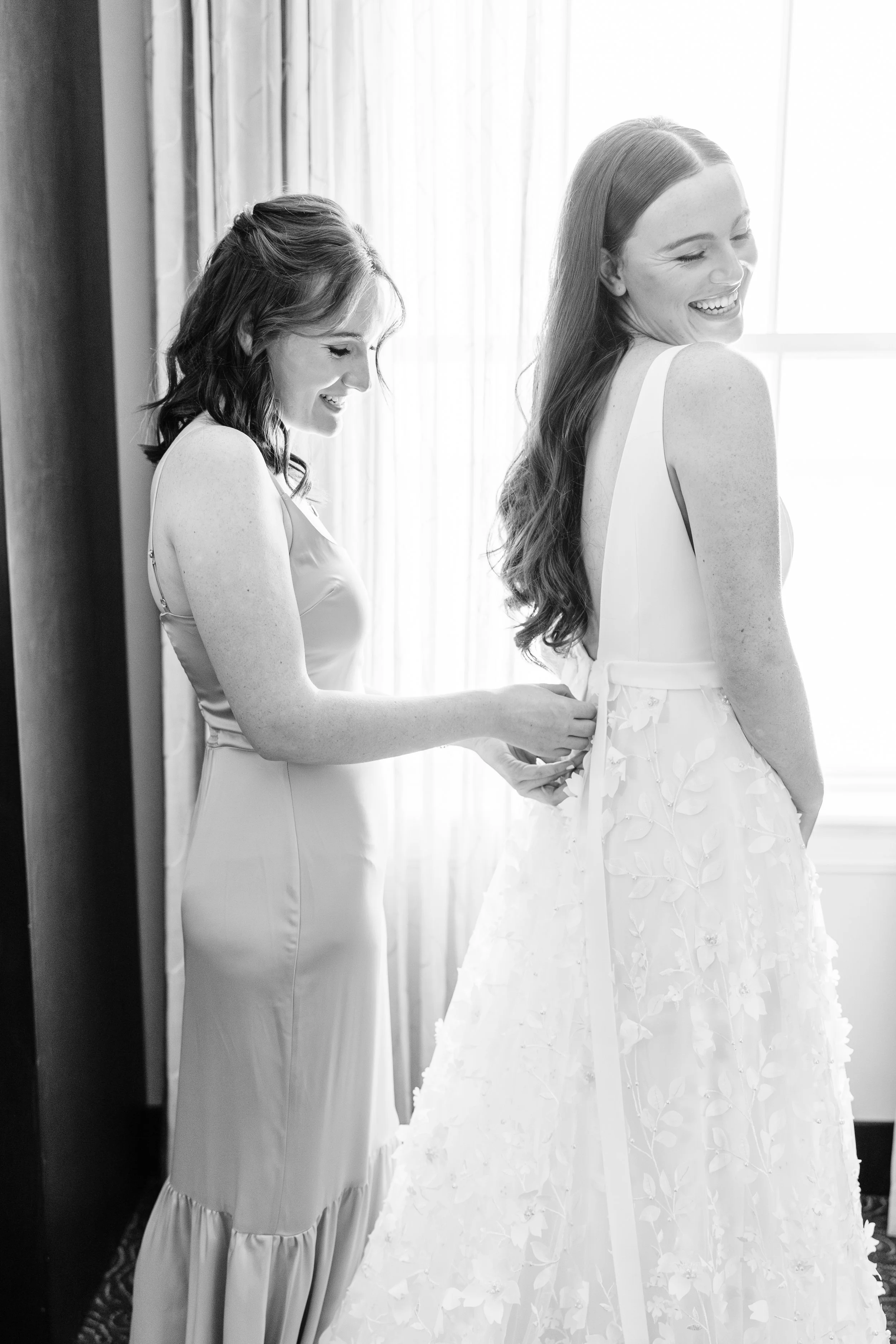 Bride putting on wedding dress in bridal suite at Baton Rouge wedding