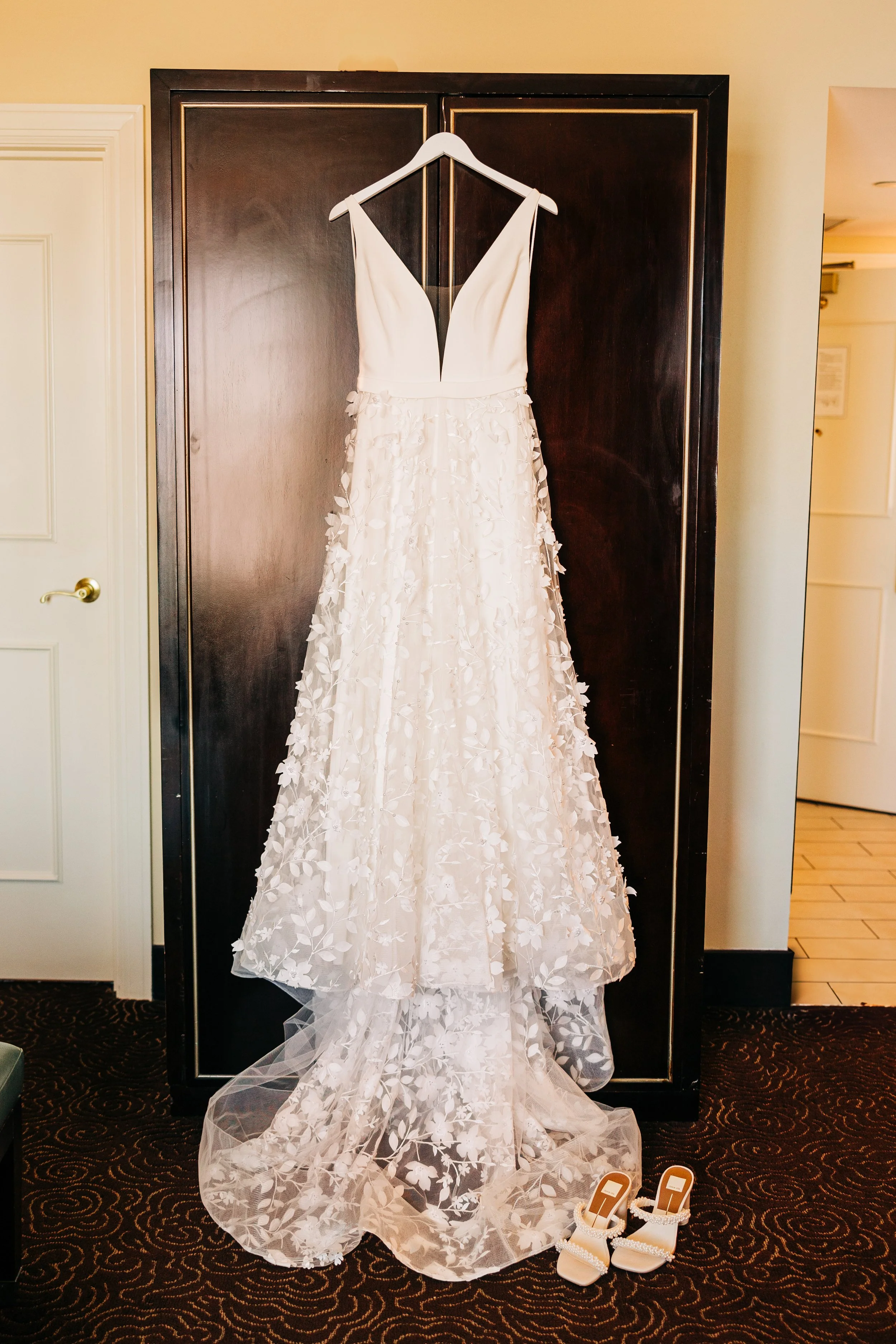 Wedding dress hanging on door during getting ready in the bridal suite before Baton Rouge wedding