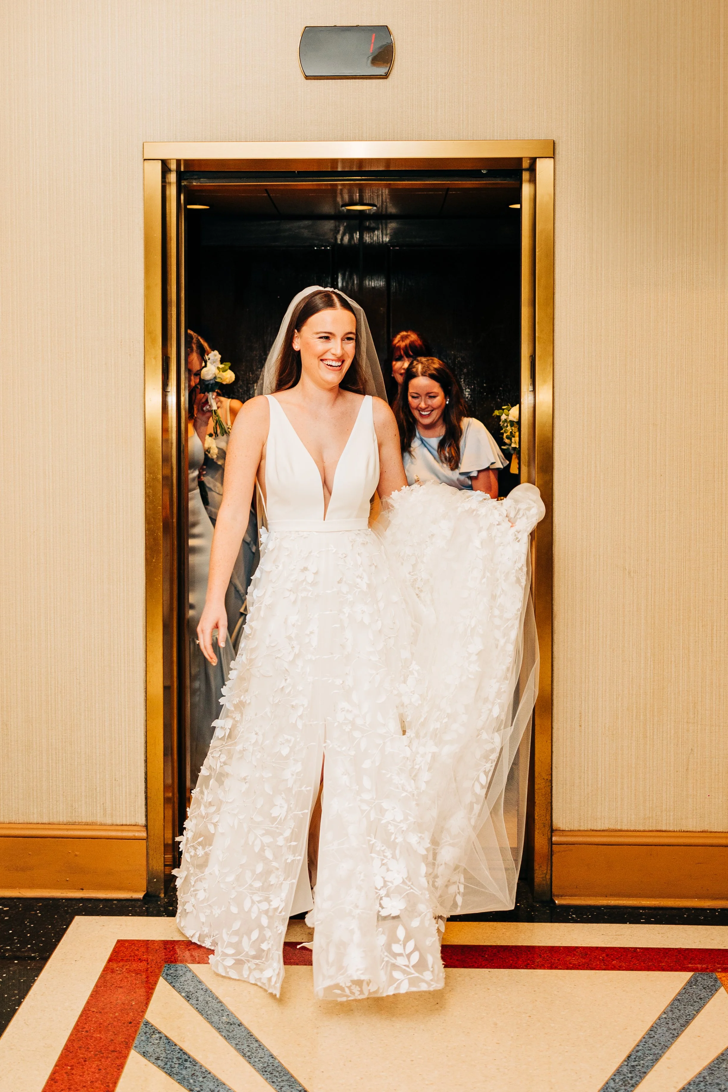 bride and bridesmaids exit elevator leaving bridal suite at baton rouge wedding